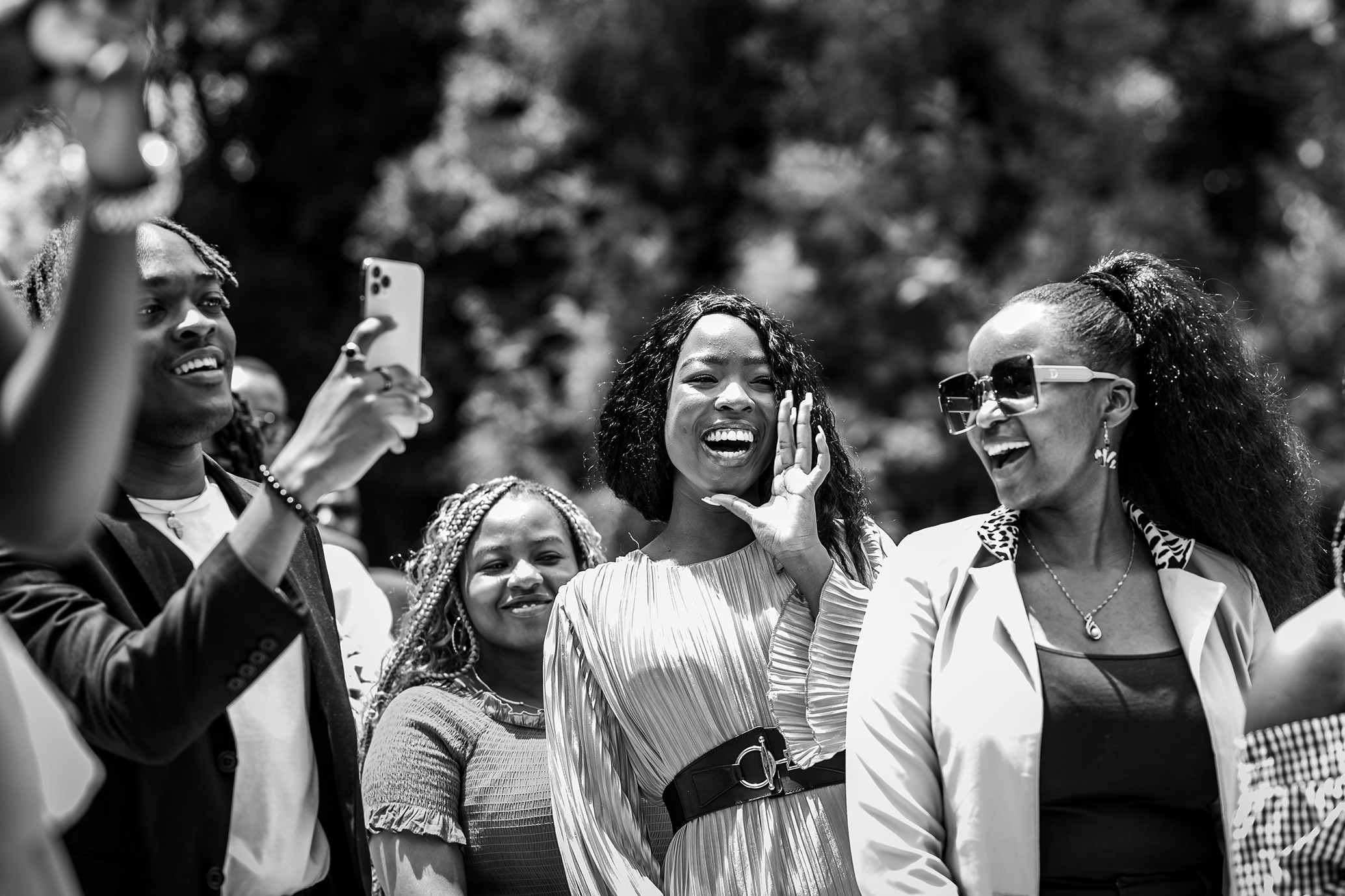 A black and white photo of wedding guests cheering on, at a wedding in Nairobi.
