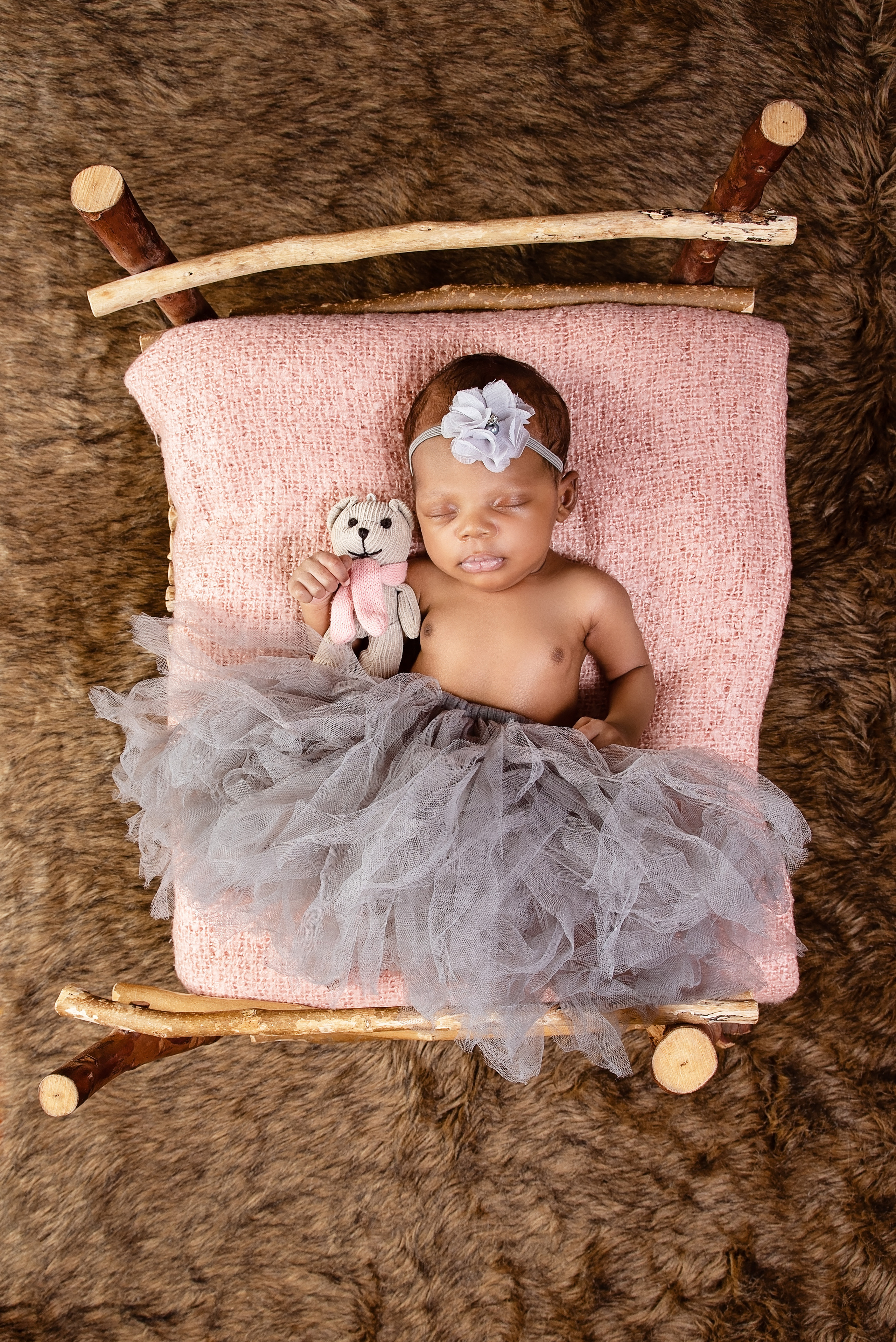Black 2 months baby girl laying in the wooden bed newborn photo shoot Mombasa Kenya