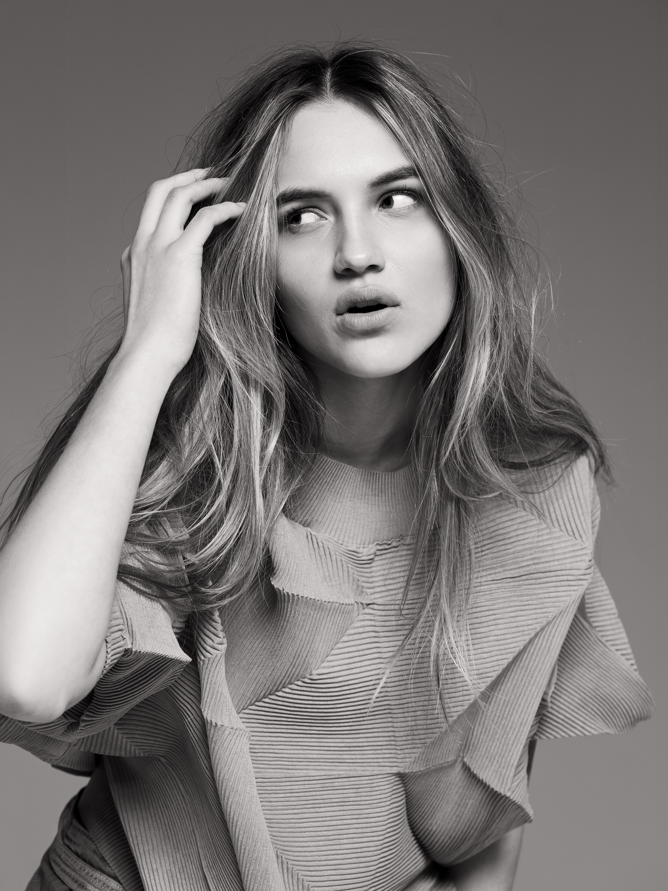 teenage girl studio portrait, hand near forehead, black and white