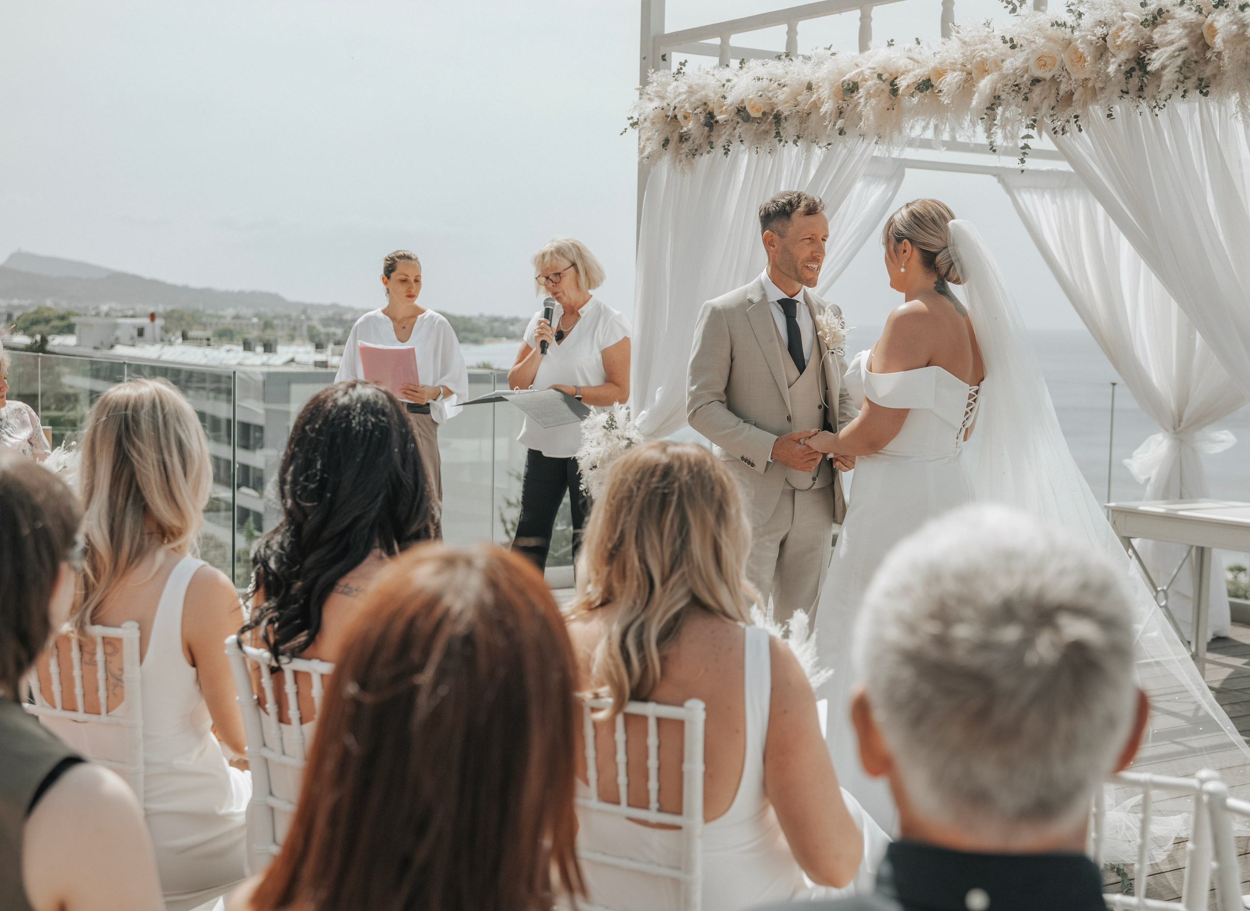 Bride and groom exchanging vows with a stunning view of the Aegean Sea in the background in Sheraton hotel, Greece, Rhodes