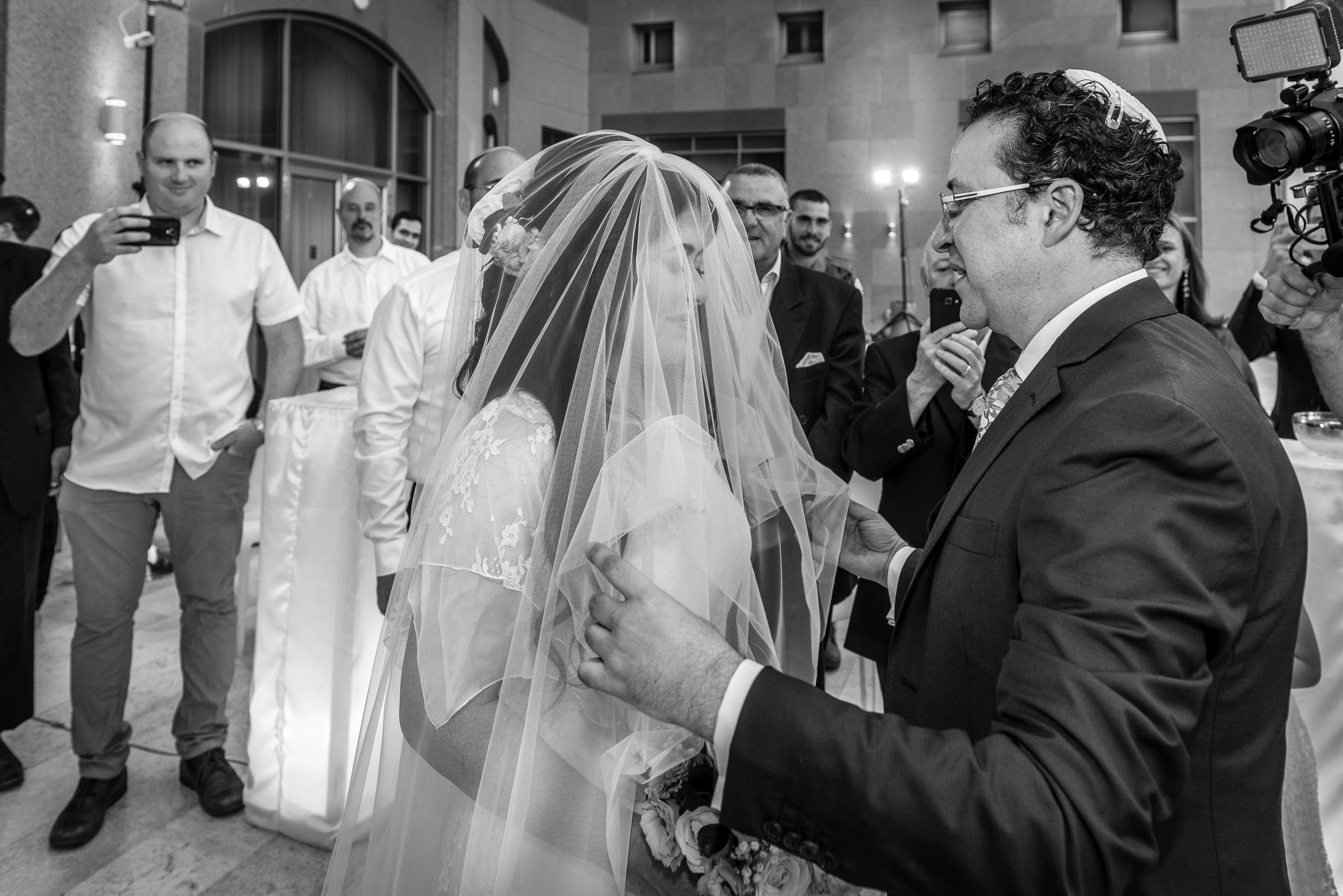 Groom Michael covering bride Simone with a veil during the traditional ceremony at the Leonardo Hotel in Haifa, Israel