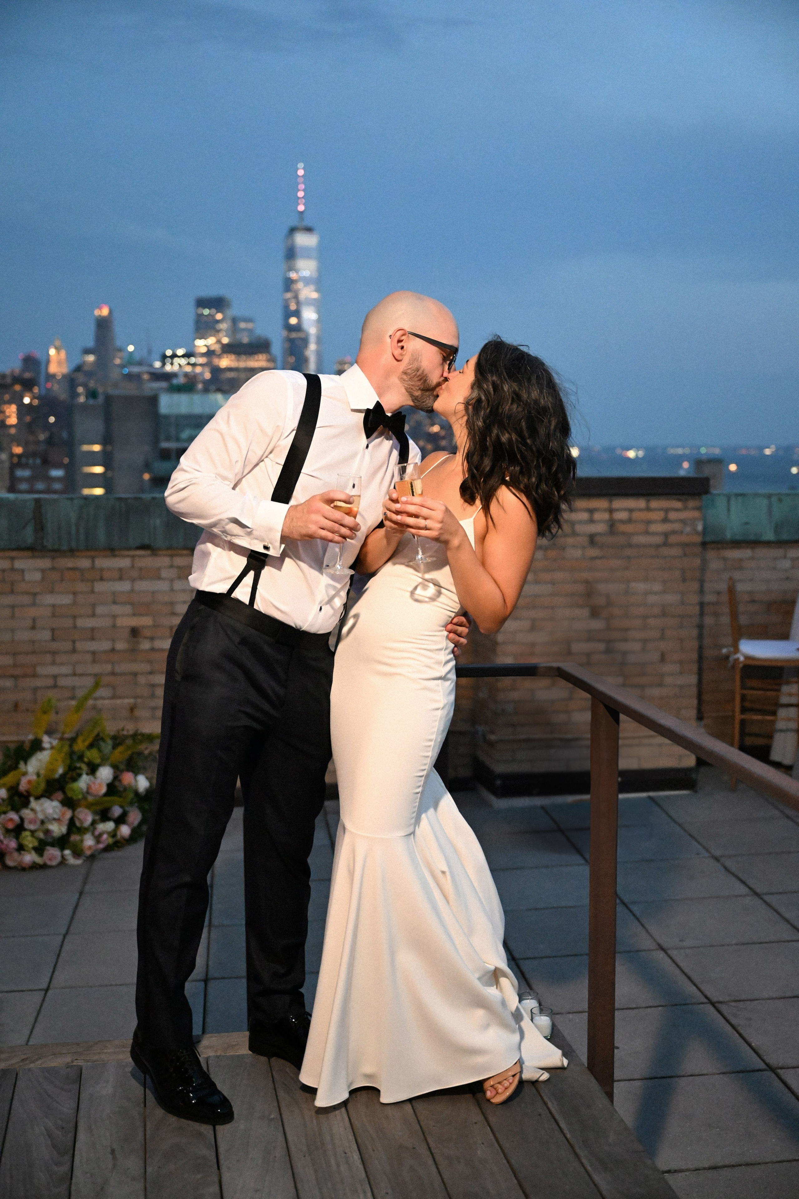 a bride and groom share a kiss on a rooftop