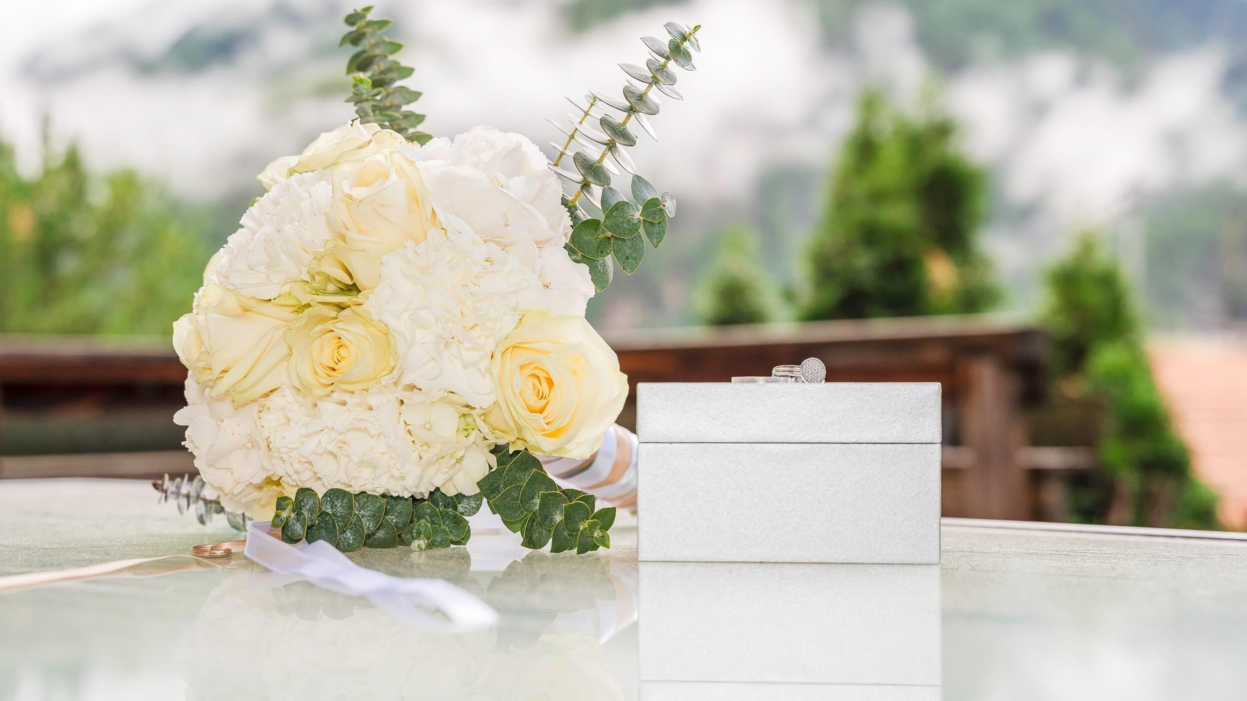 Brautstrauß und Hochzeitseinladung als festliche Hochzeitstischdekoration in Sölden, Tirol.