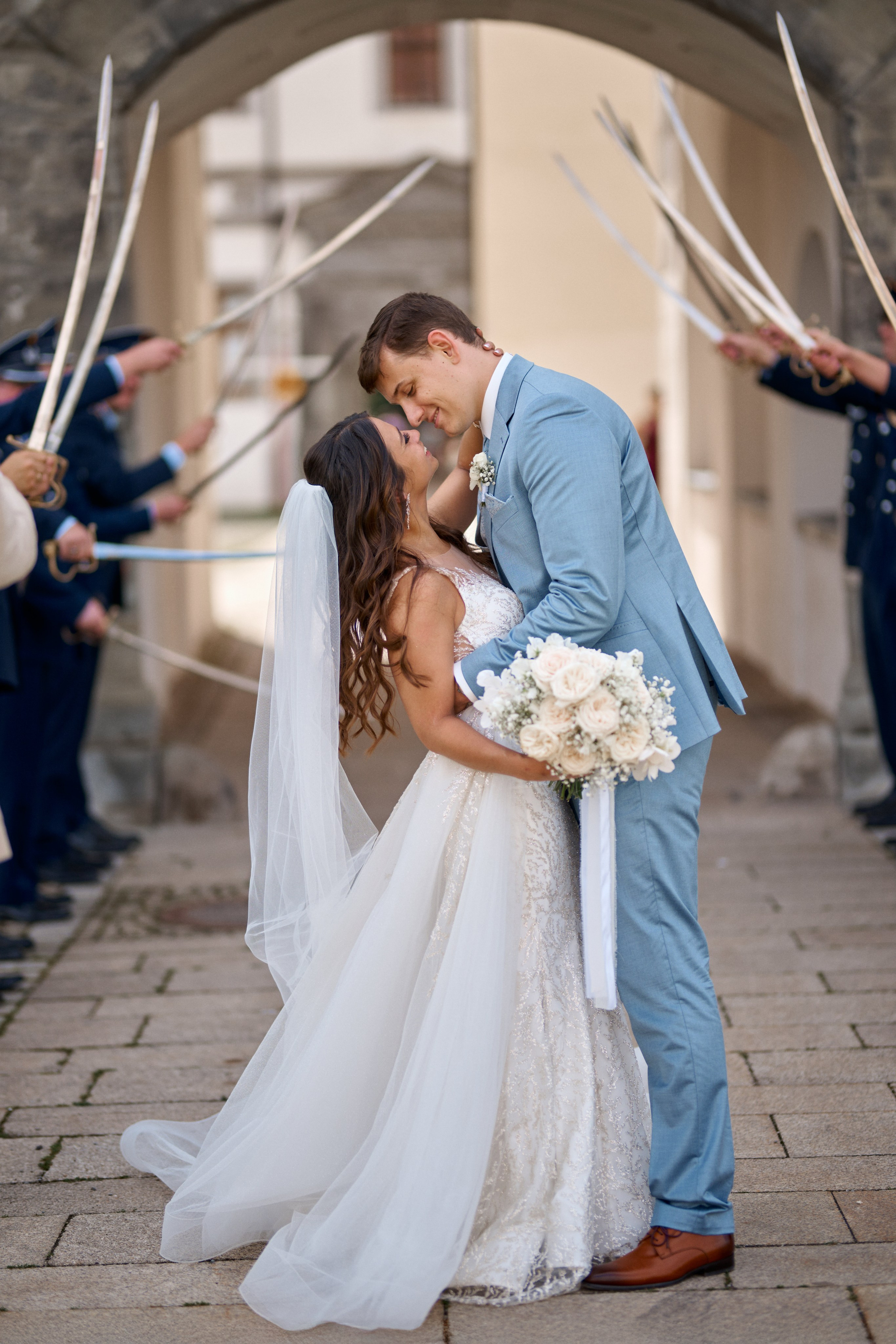 Alessandra & Nils küssen sich unter dem Schwertbogen der Militärparade – ein ikonischer Moment nach ihrer kirchlichen Trauung in Meßkirch.