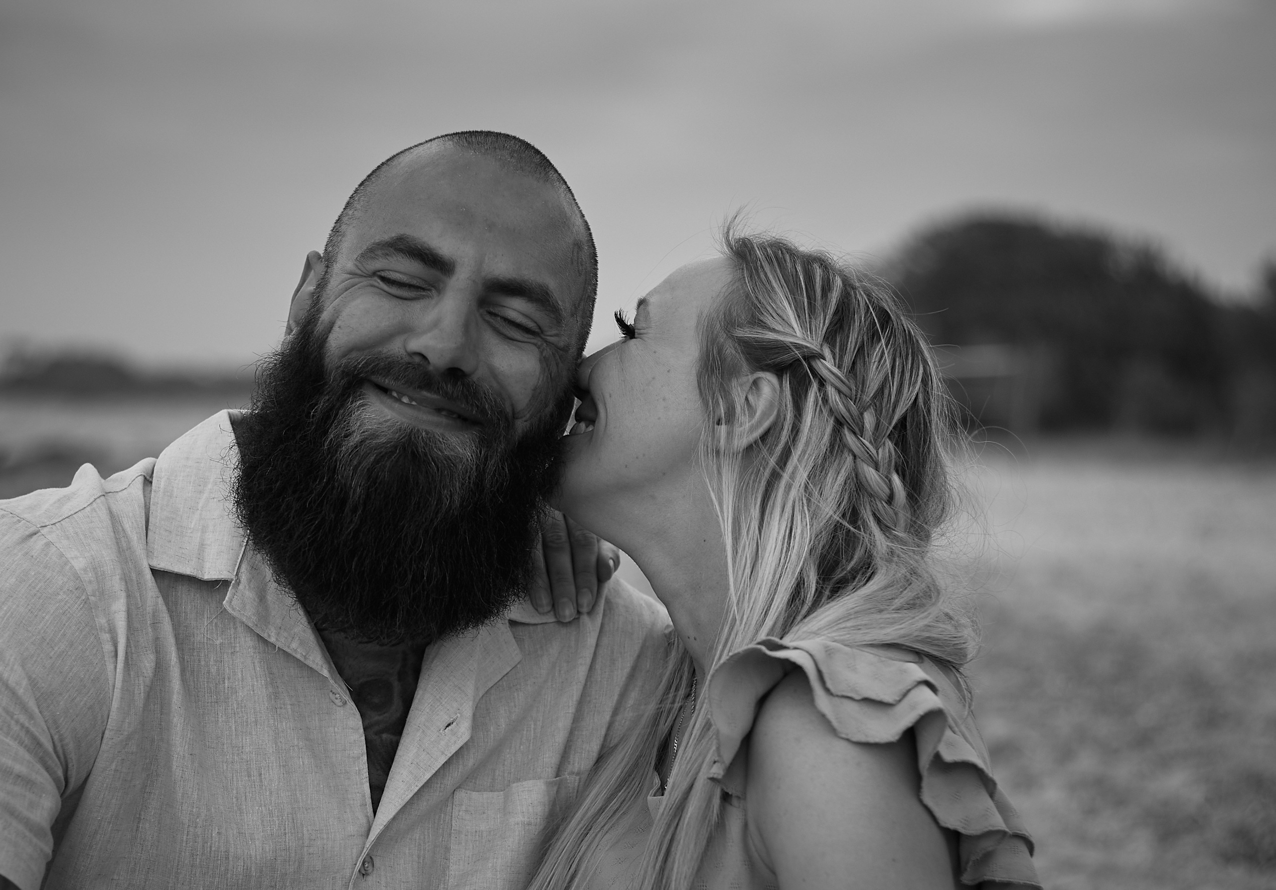 Girl kisses smiling man, happy couple