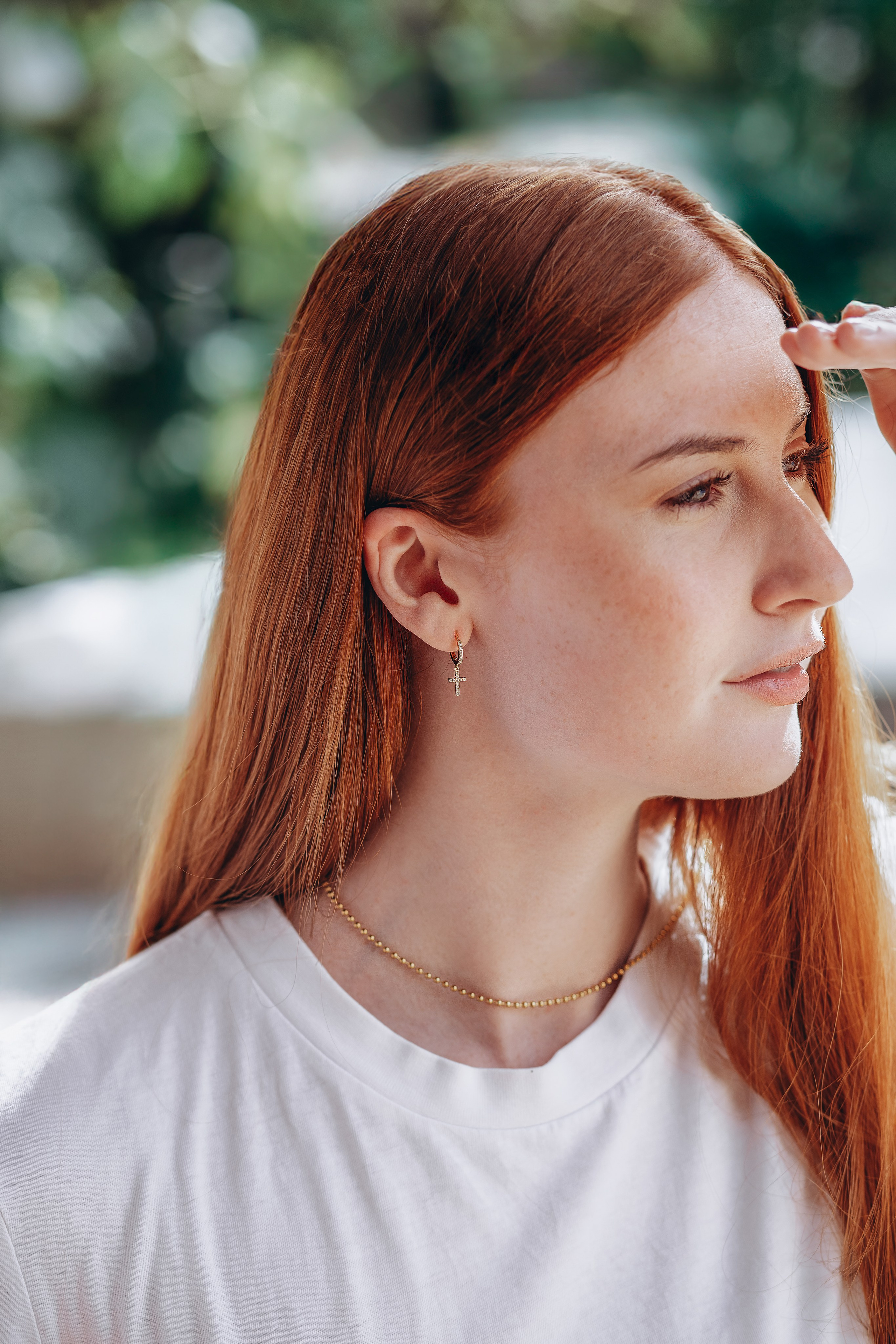 Natural light portrait of a young woman with red hair showcasing delicate gold jewelry, taken during a brand photography session in Valencia, Spain — ideal for businesses seeking lifestyle, content, or product photoshoots in Valencia and across Spain.