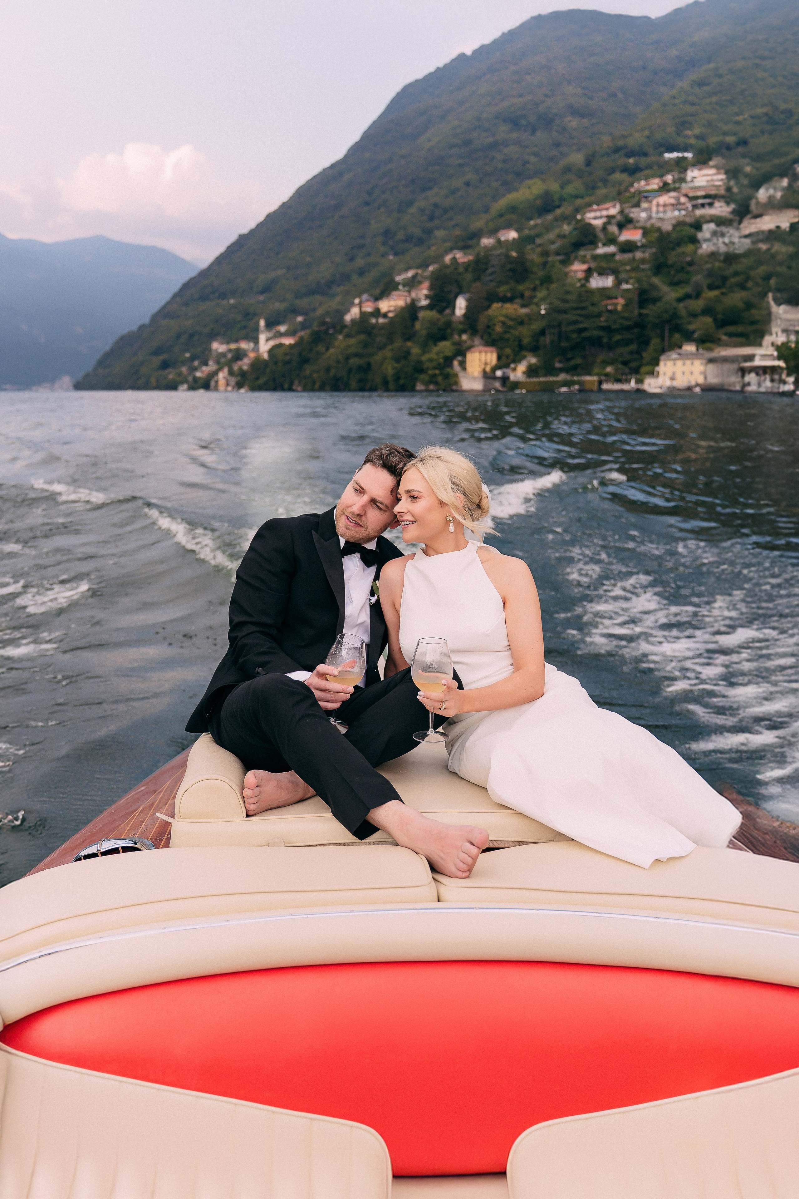 Bride and groom cruising Lake Como by boat at Villa Lario, Italy
