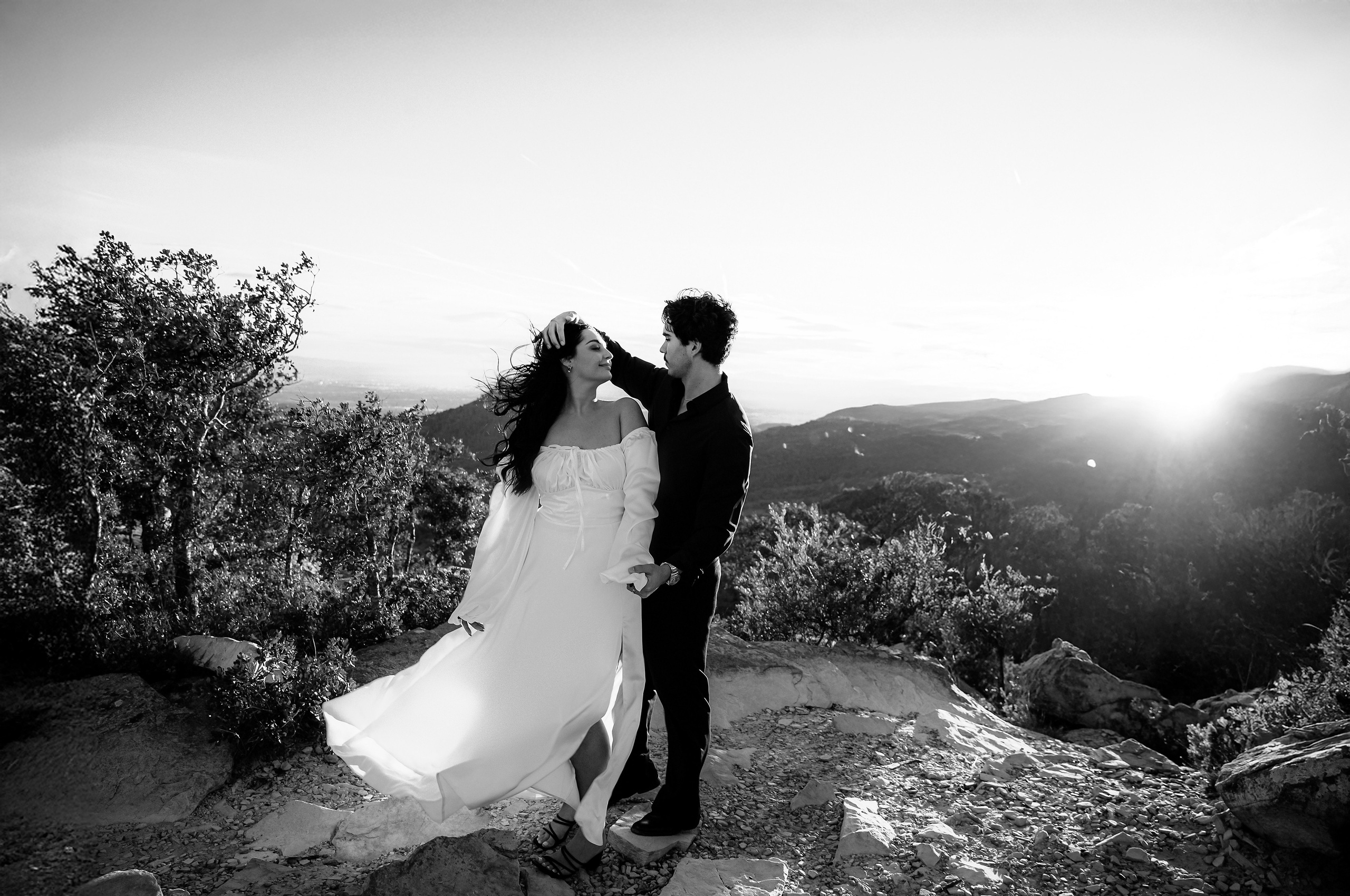 Bride and groom dancing on a rocky cliff during a cinematic mountain elopement in Barcelona, Spain. This dramatic black and white wedding portrait highlights the freedom and intimacy of a destination wedding.