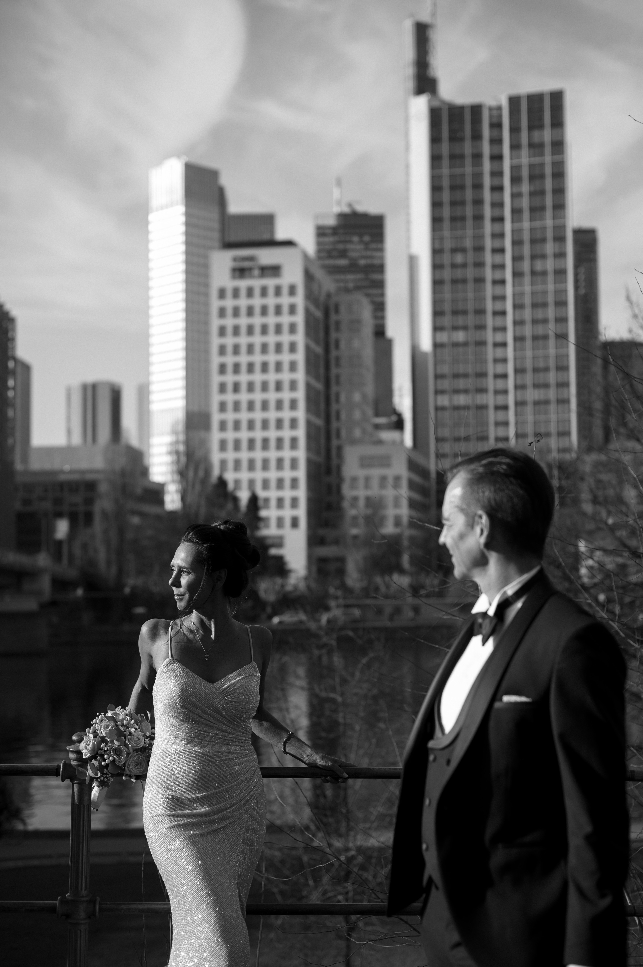Brautpaar am Mainufer in Frankfurt mit Skyline im Hintergrund, Hochzeitsfotografie in der Stadt