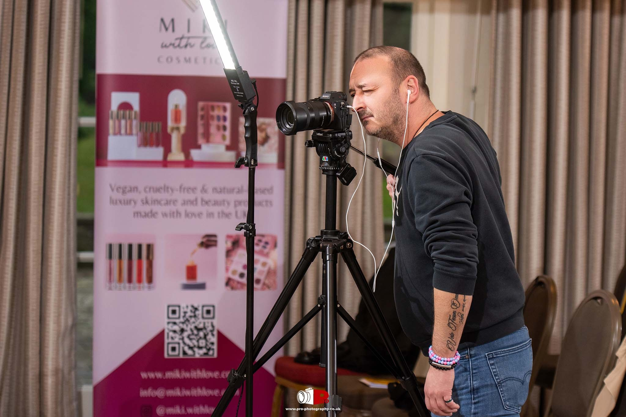 A professional photographer focuses through a camera lens during a corporate event.