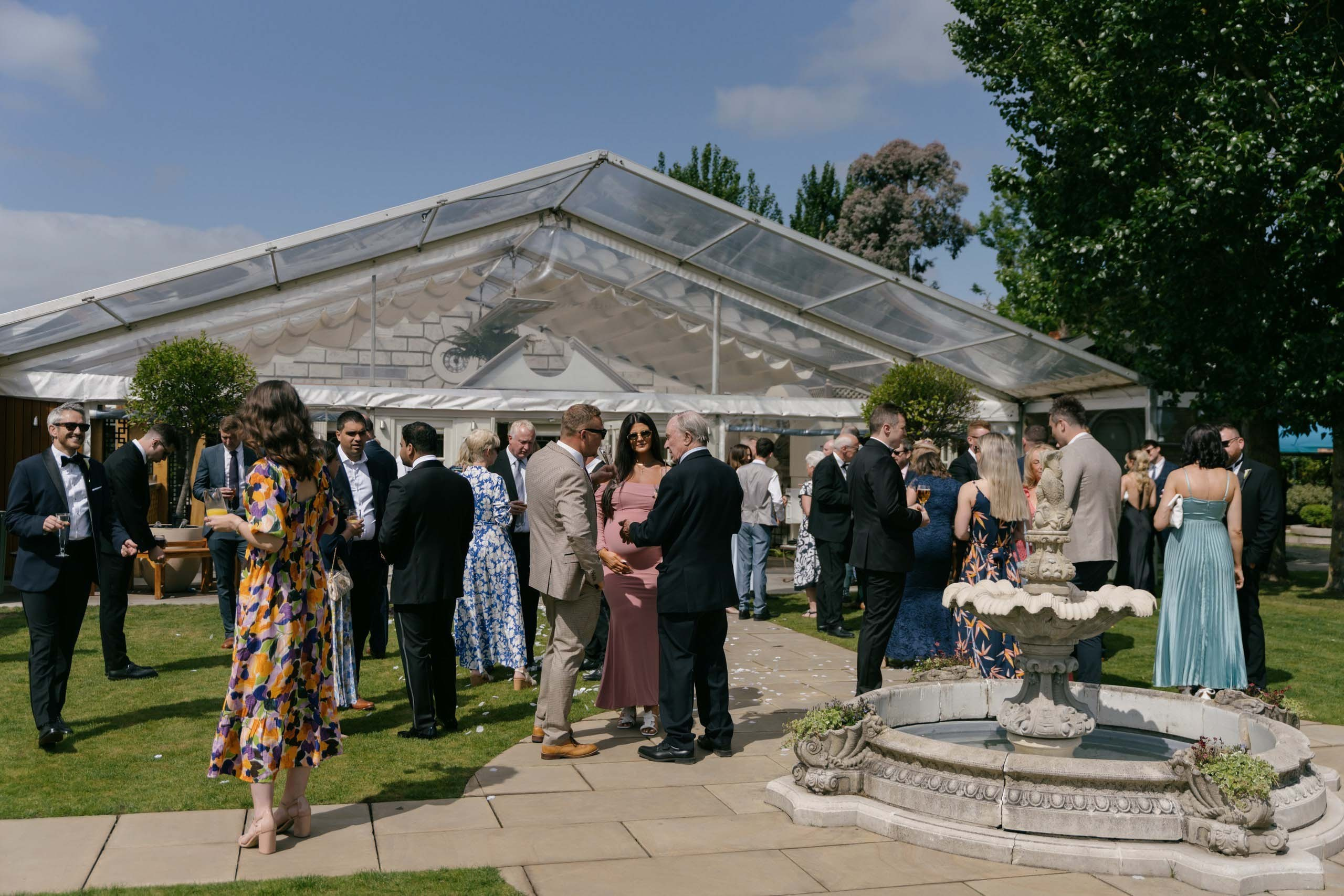 Wedding guests gathering outside marquee Friern Manor Essex reception