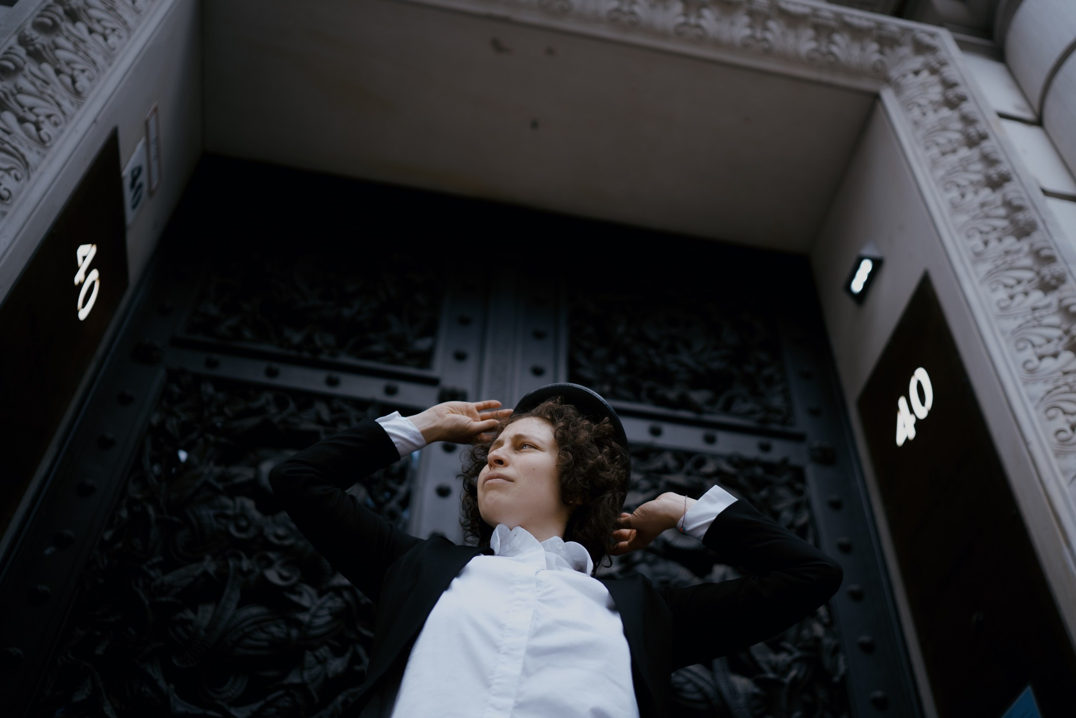 Kreatives Portrait, Frau steht vor monumentalem Eingangstor