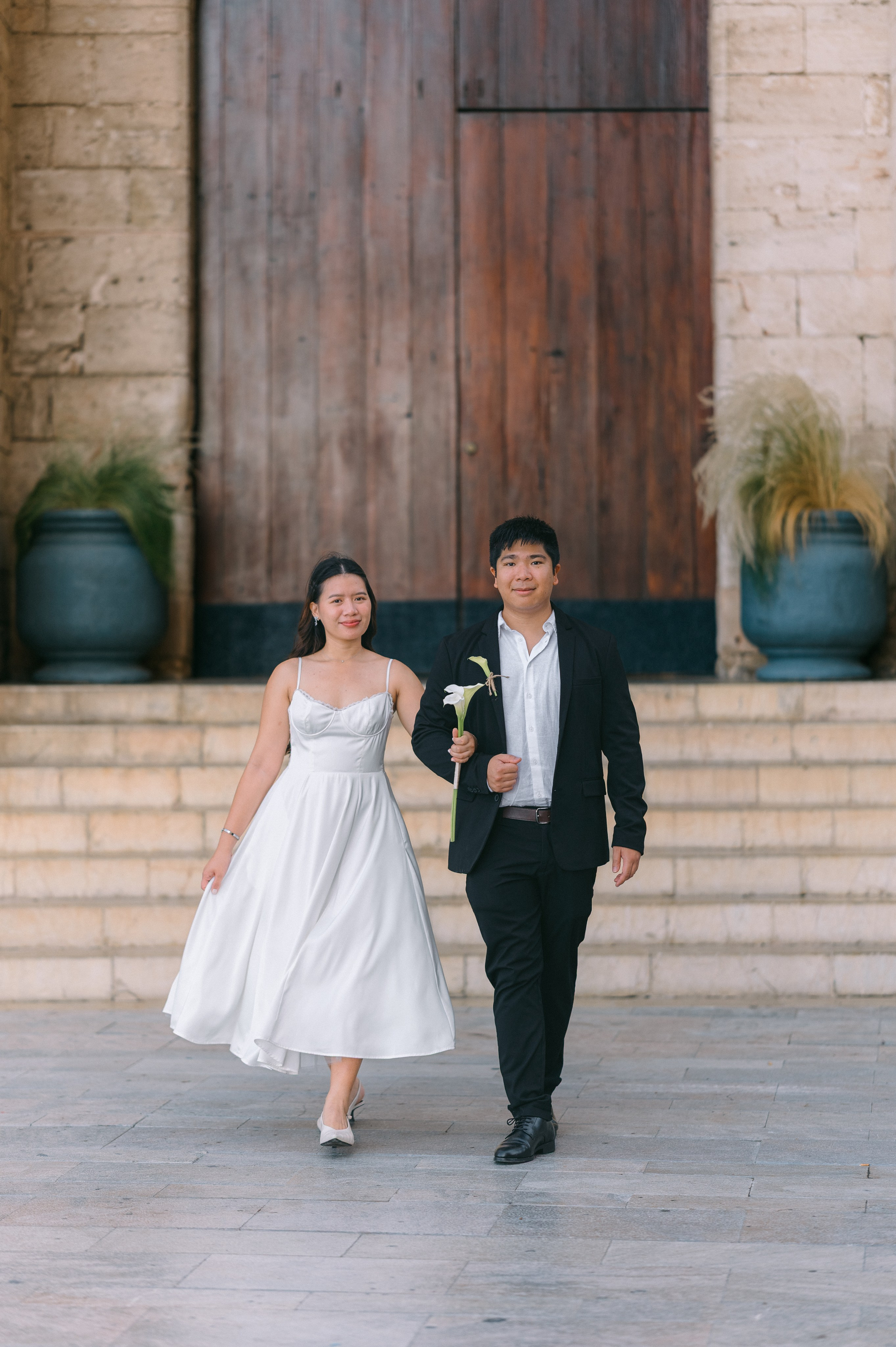 Newlywed couple walking down historic steps in Palma de Mallorca