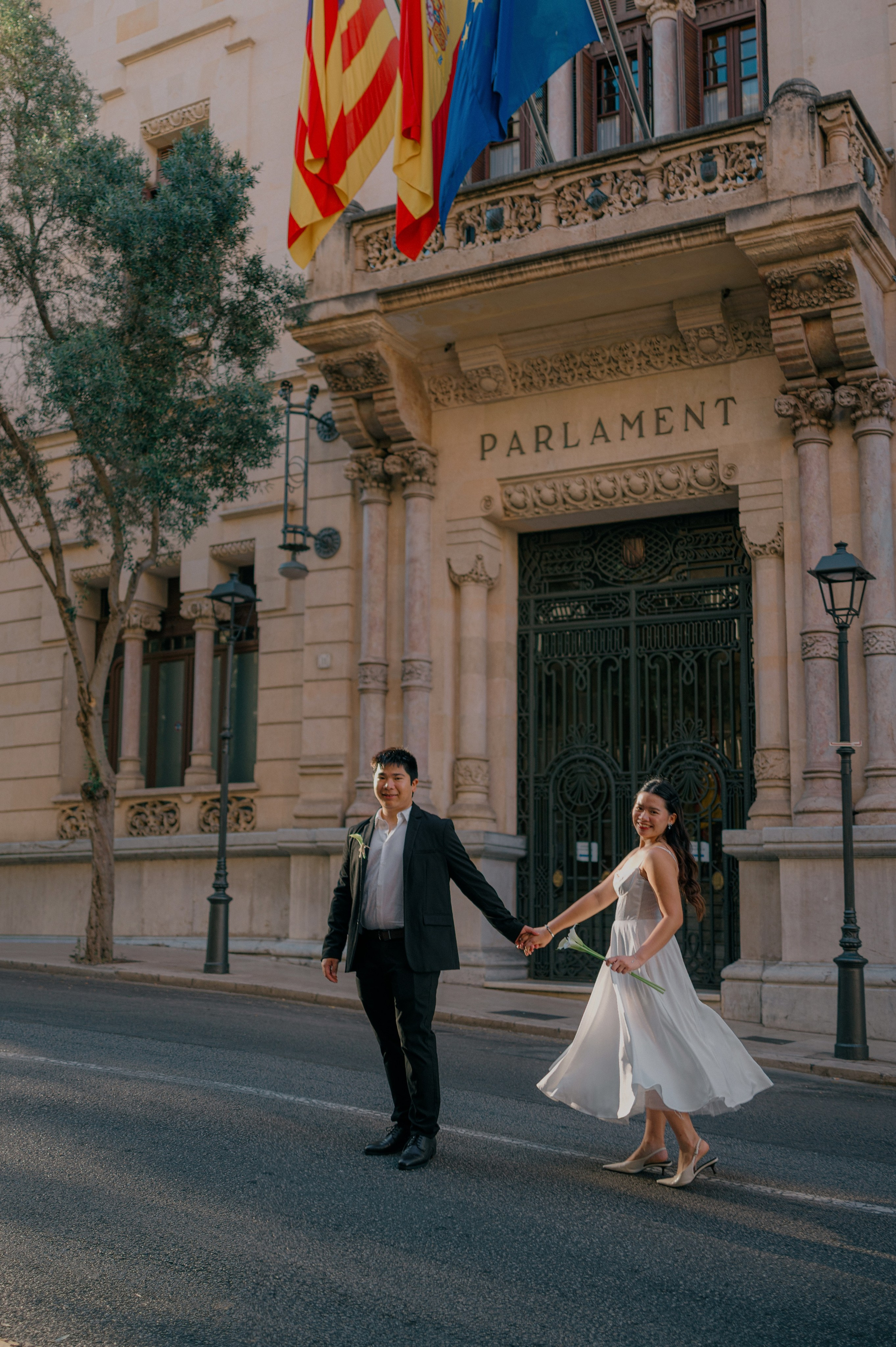 Newlywed couple walking outside the Parliament in Palma de Mallorca