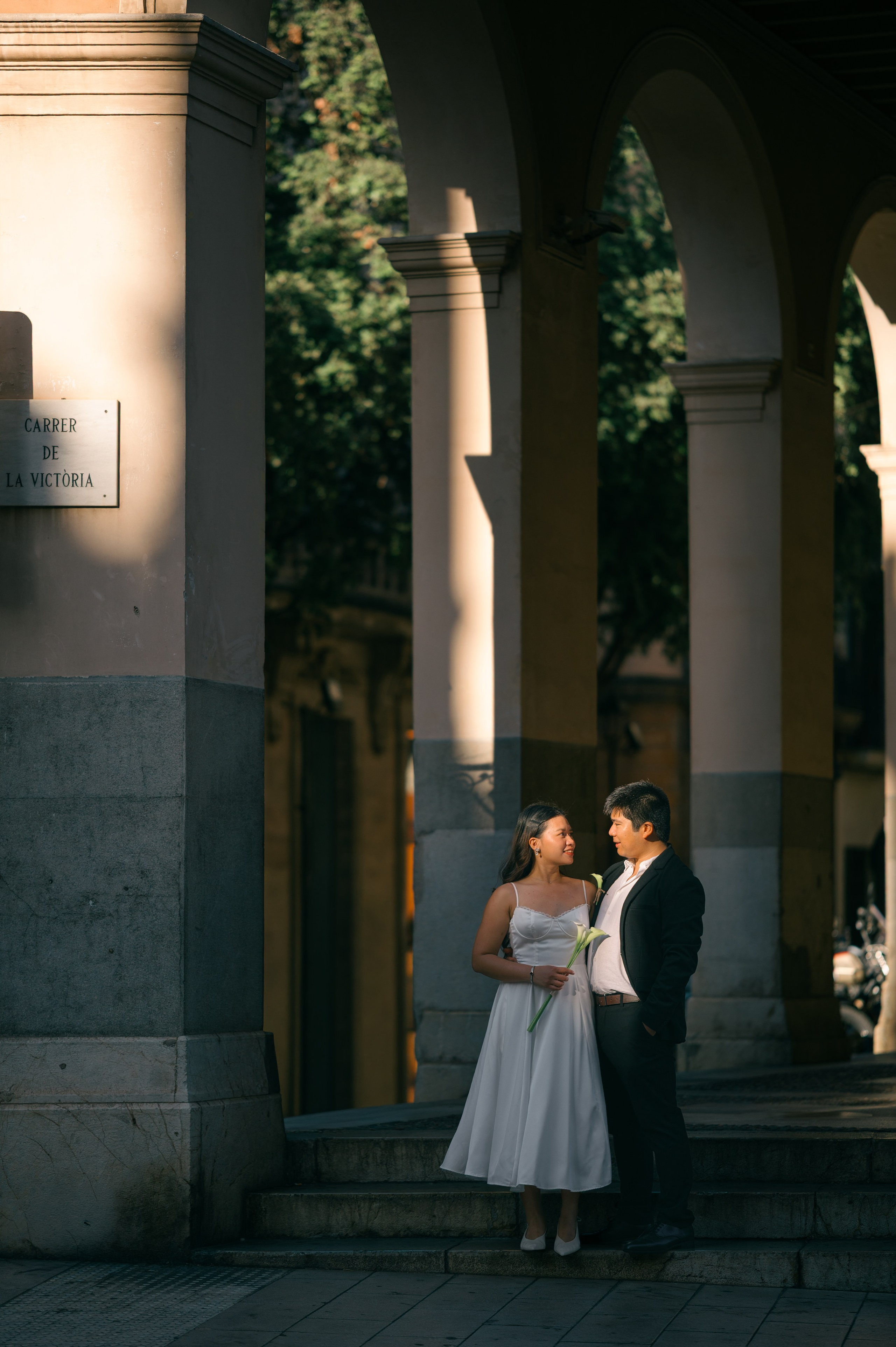 Wedding couple standing beneath an elegant archway in Palma de Mallorca