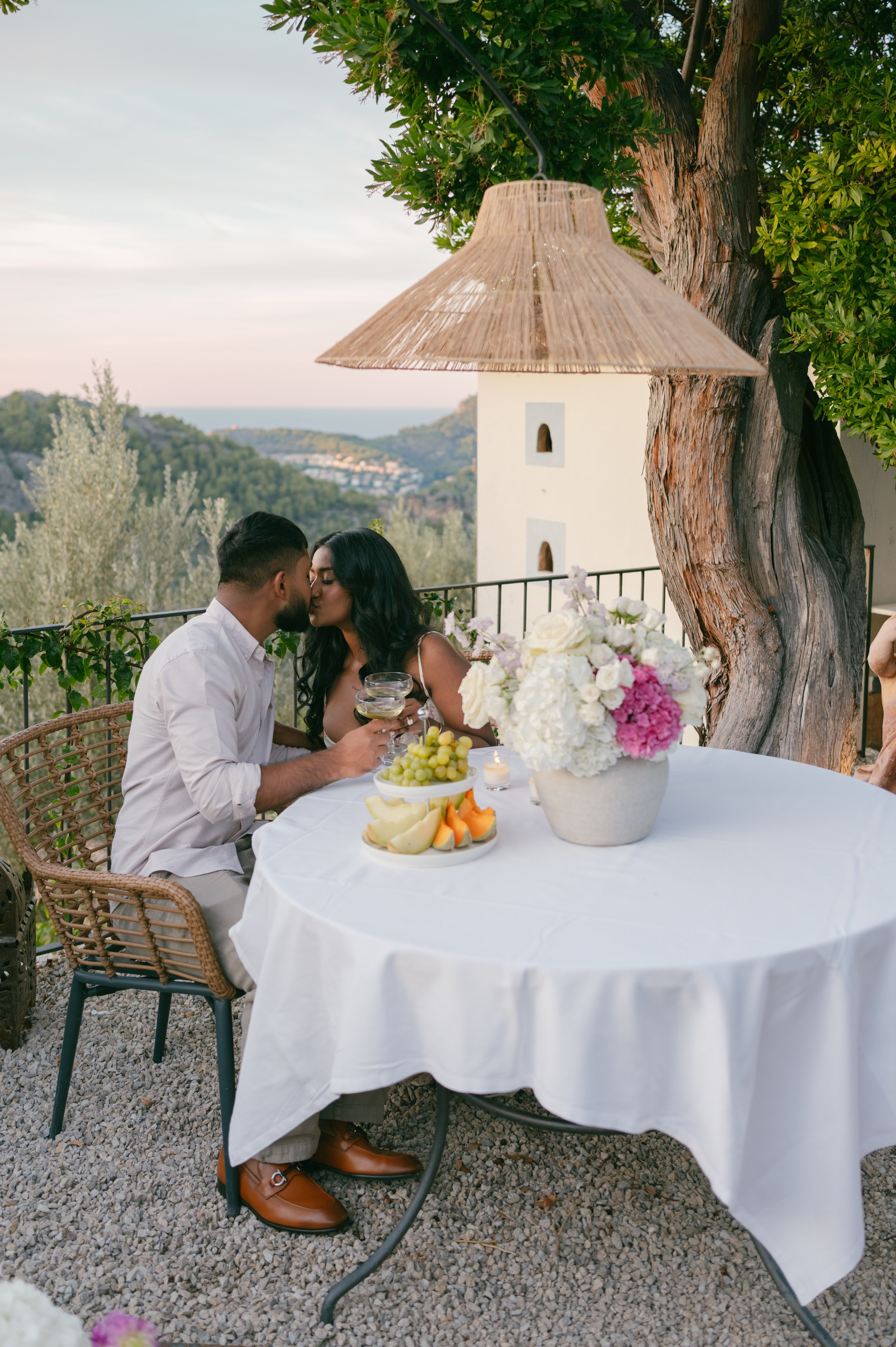 A couple kissing at their celebration dinner on a terrace in Mallorca.