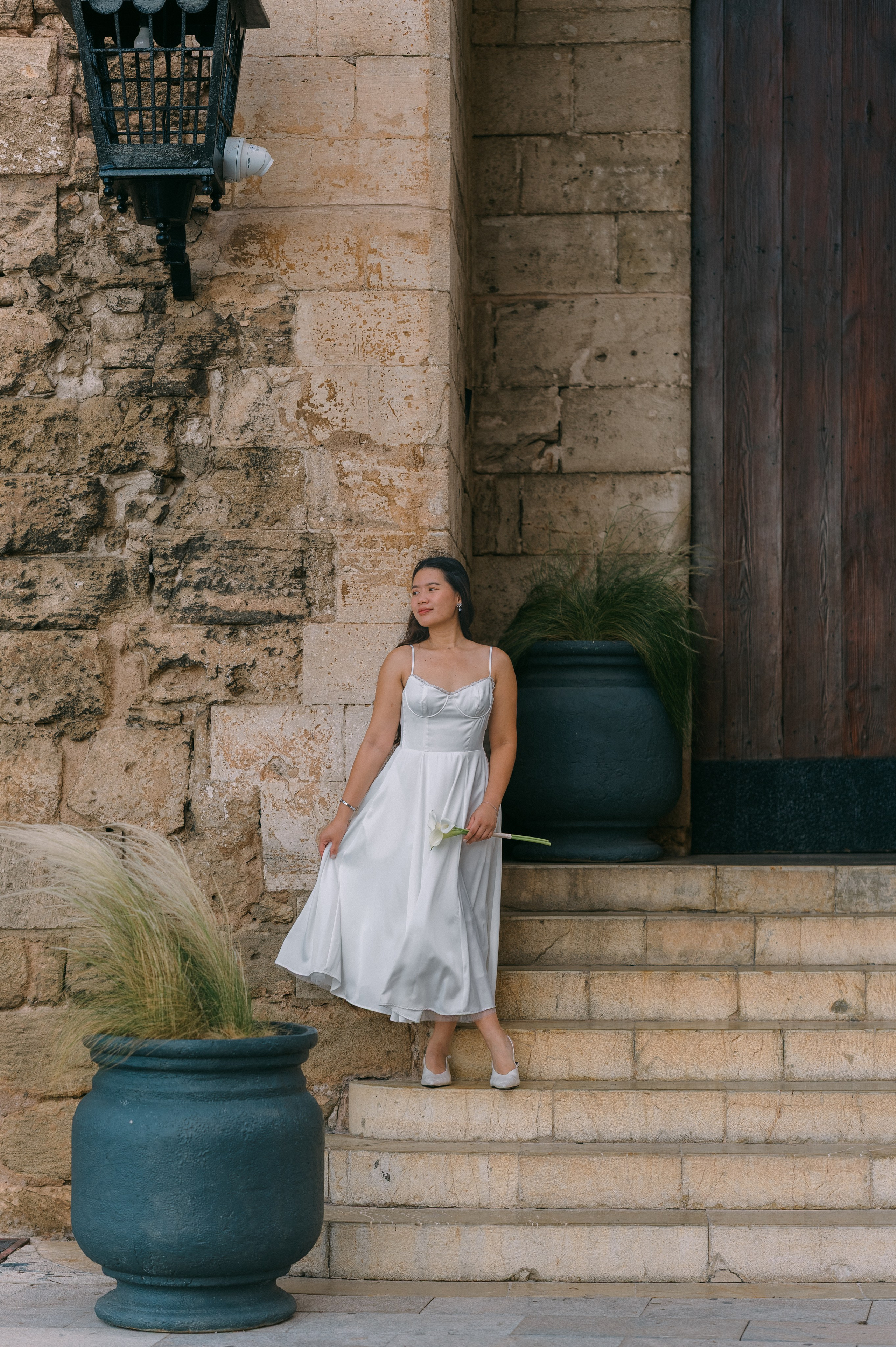 Elegant bride standing on the steps of a historic Palma building