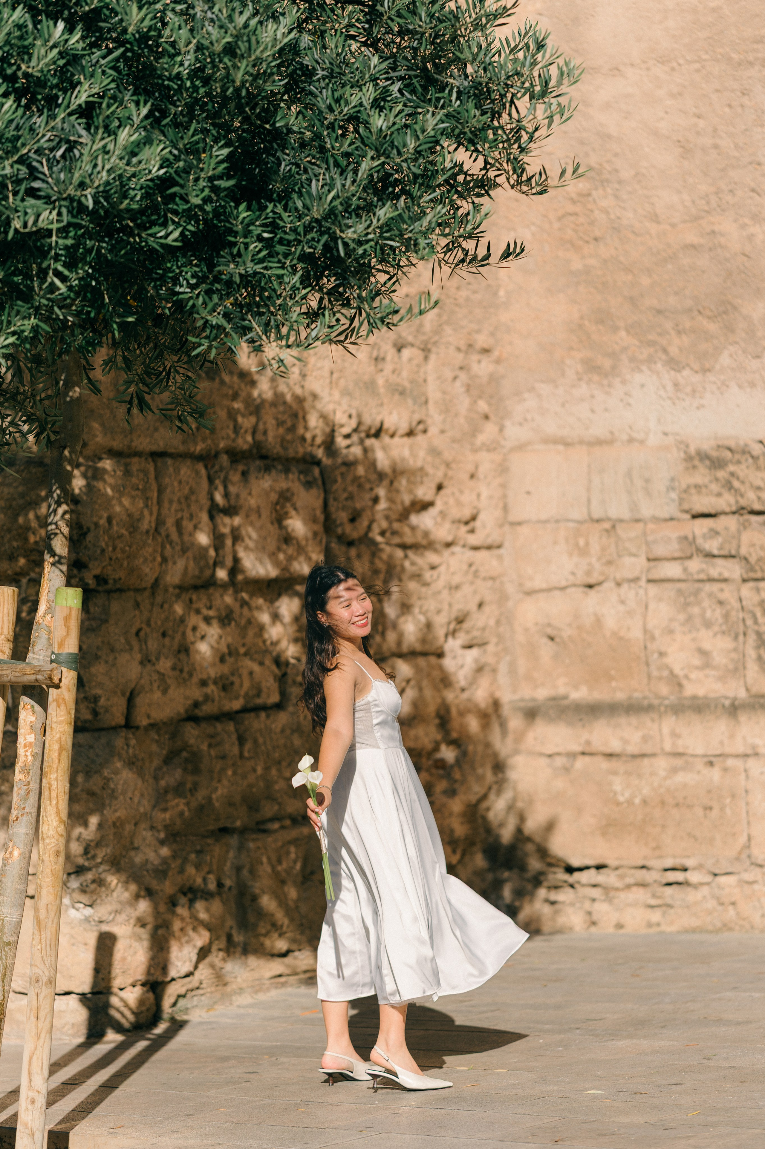 Bride walking through warm sunlight in Palma Old Town Mallorca
