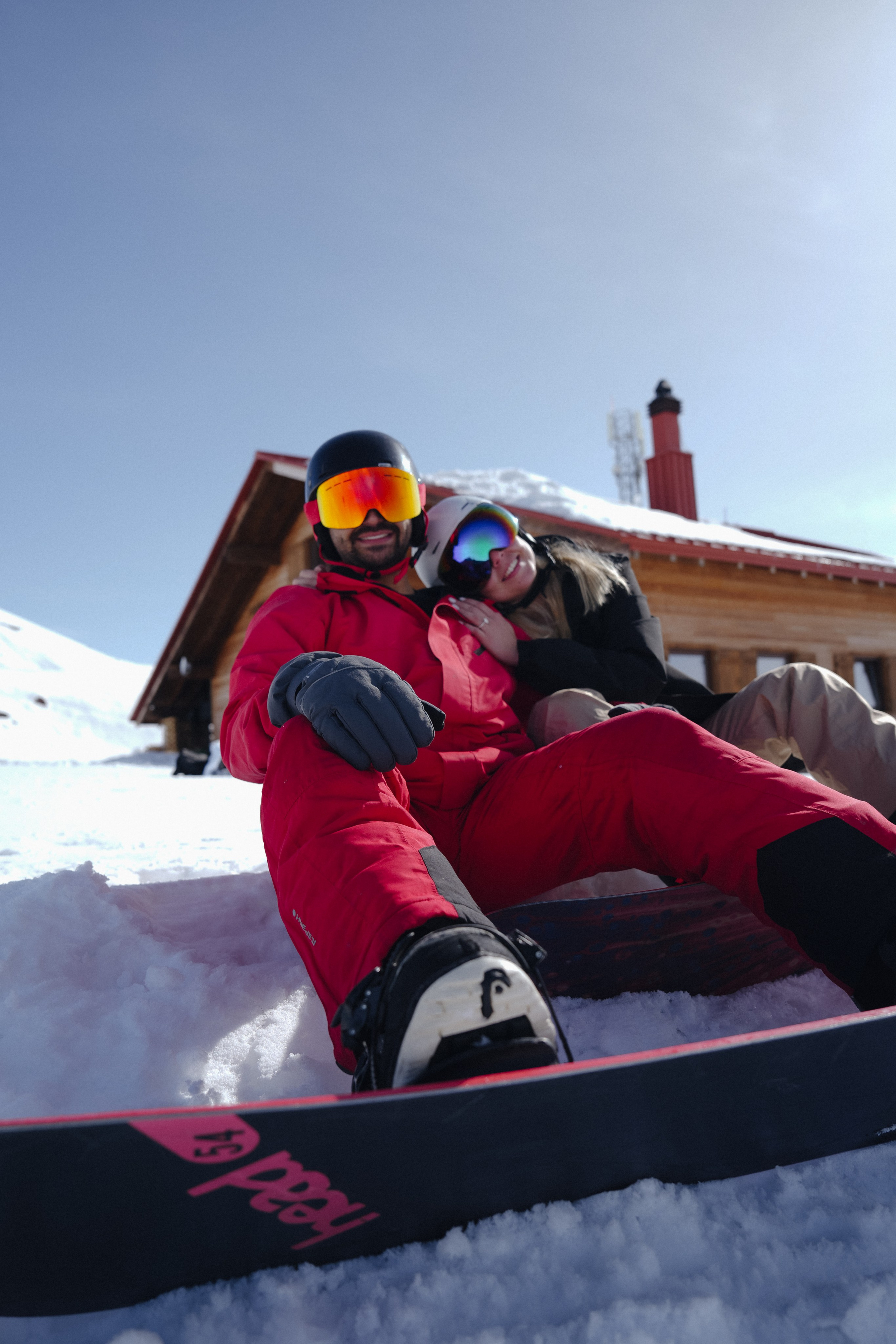 Couple on snowboards after winter engagement in Gudauri