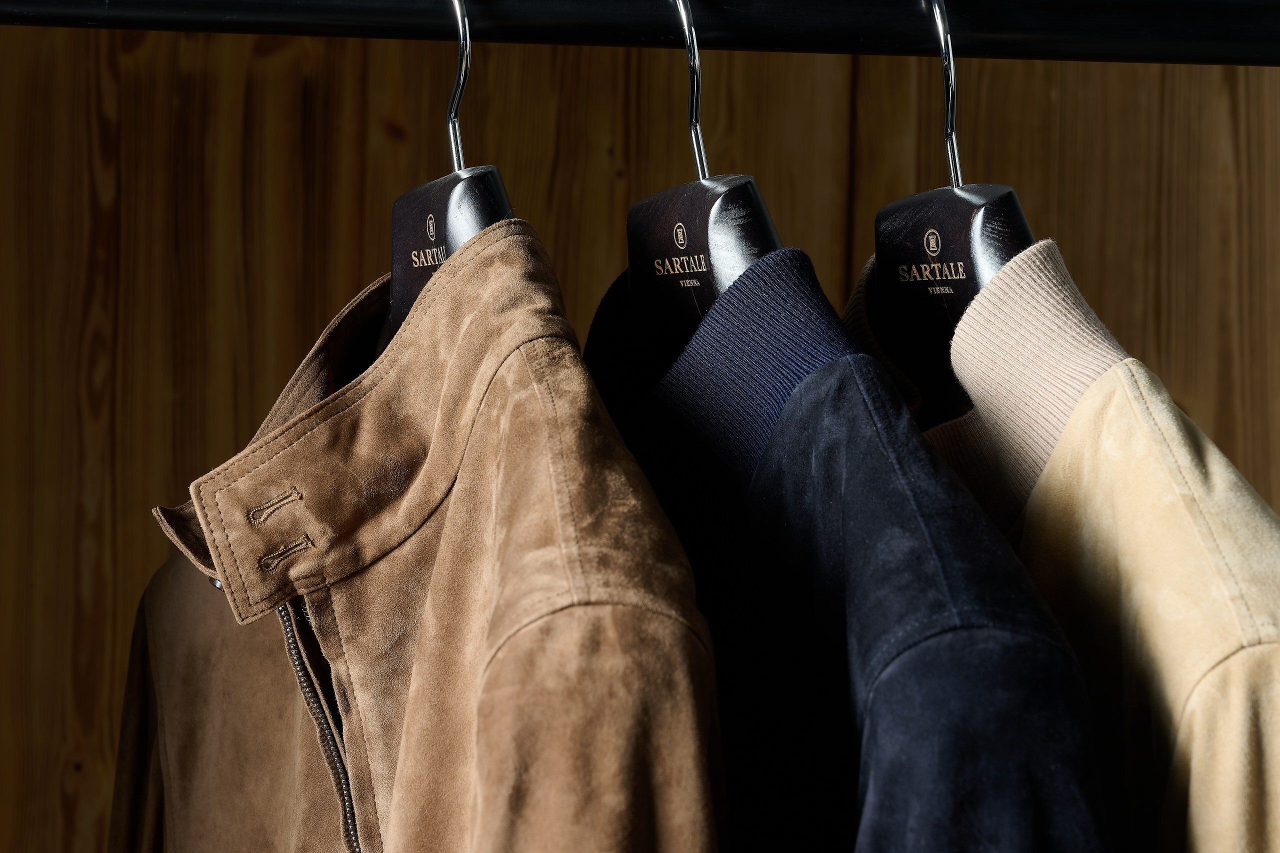 Modefotografie Wien – Detailaufnahme von Jacken auf Kleiderstange aus Metall.