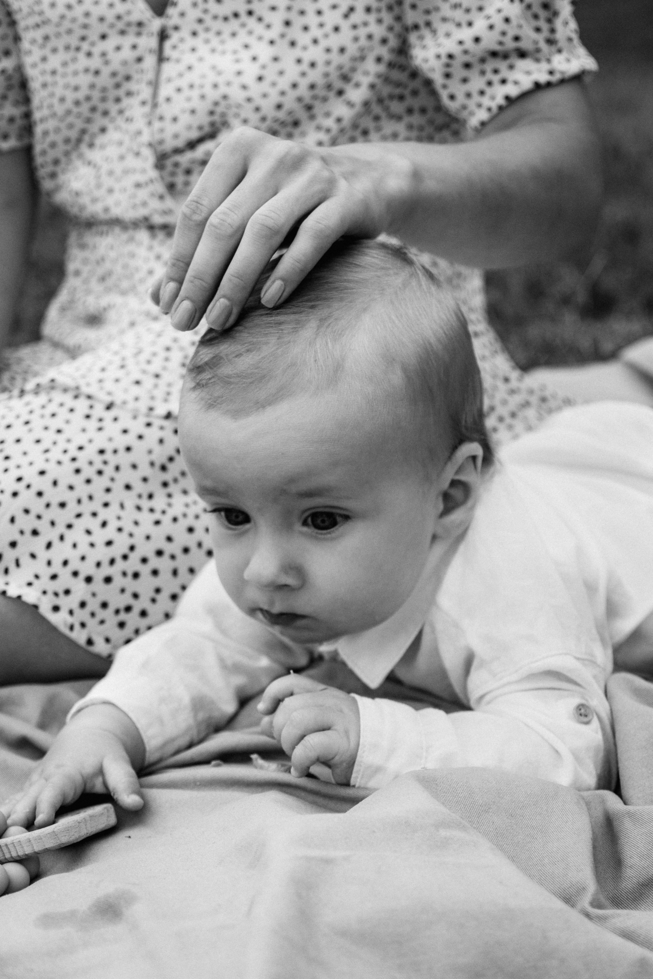 Natürliche Outdoor Babyfotografie – liebevoller Moment zwischen Mutter und Baby bei einer entspannten Lifestyle Photo Session im Freien.