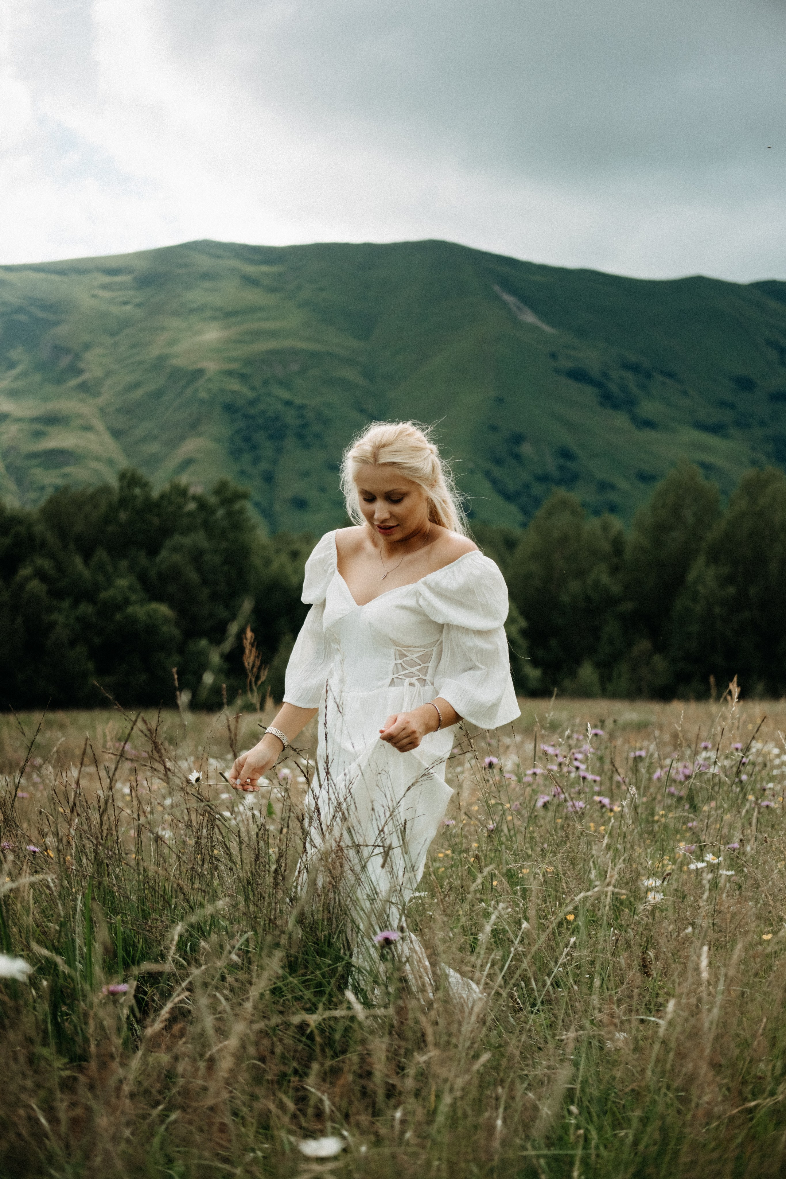 Woman walking through tall grass in Gudauri