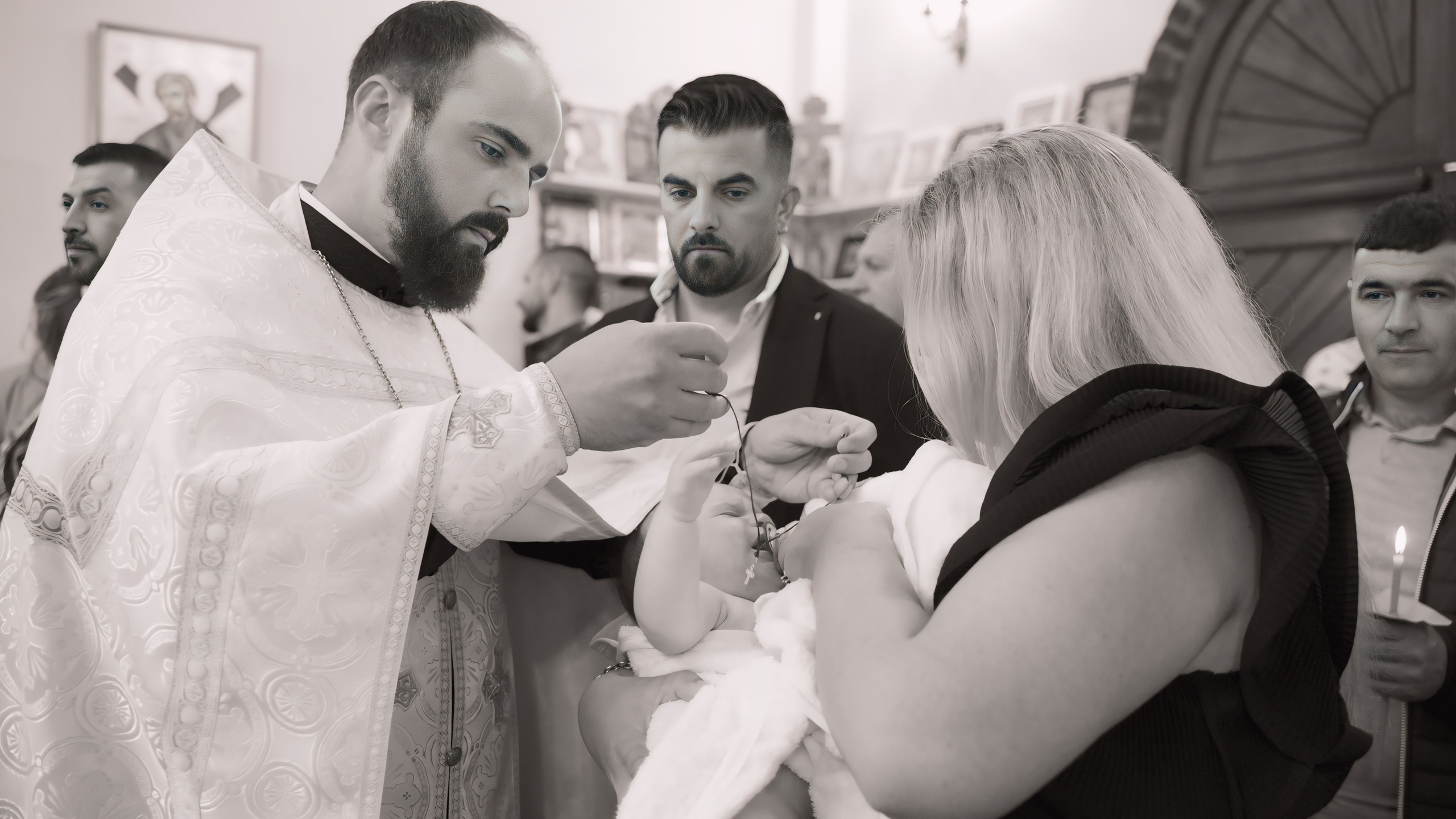 a woman holds a baby in her arms. A Christian priest holds a cross in his hands and wants to hang it around the baby's neck