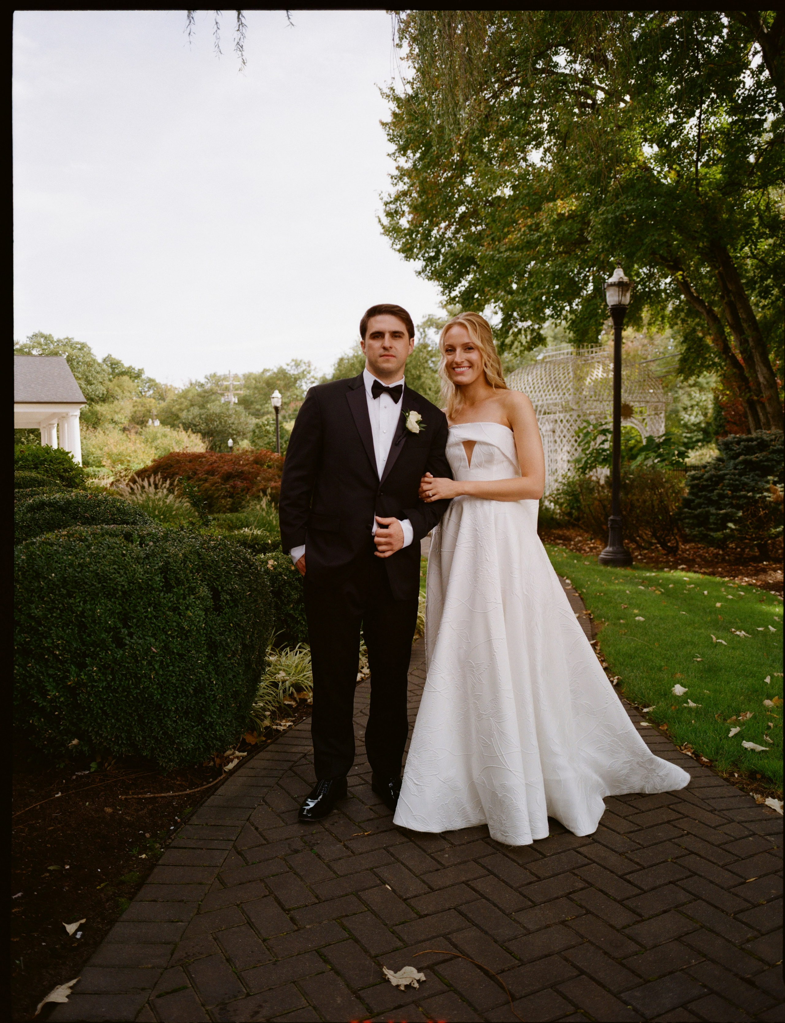 Bride and groom standing together on a garden pathway at The Rockleigh