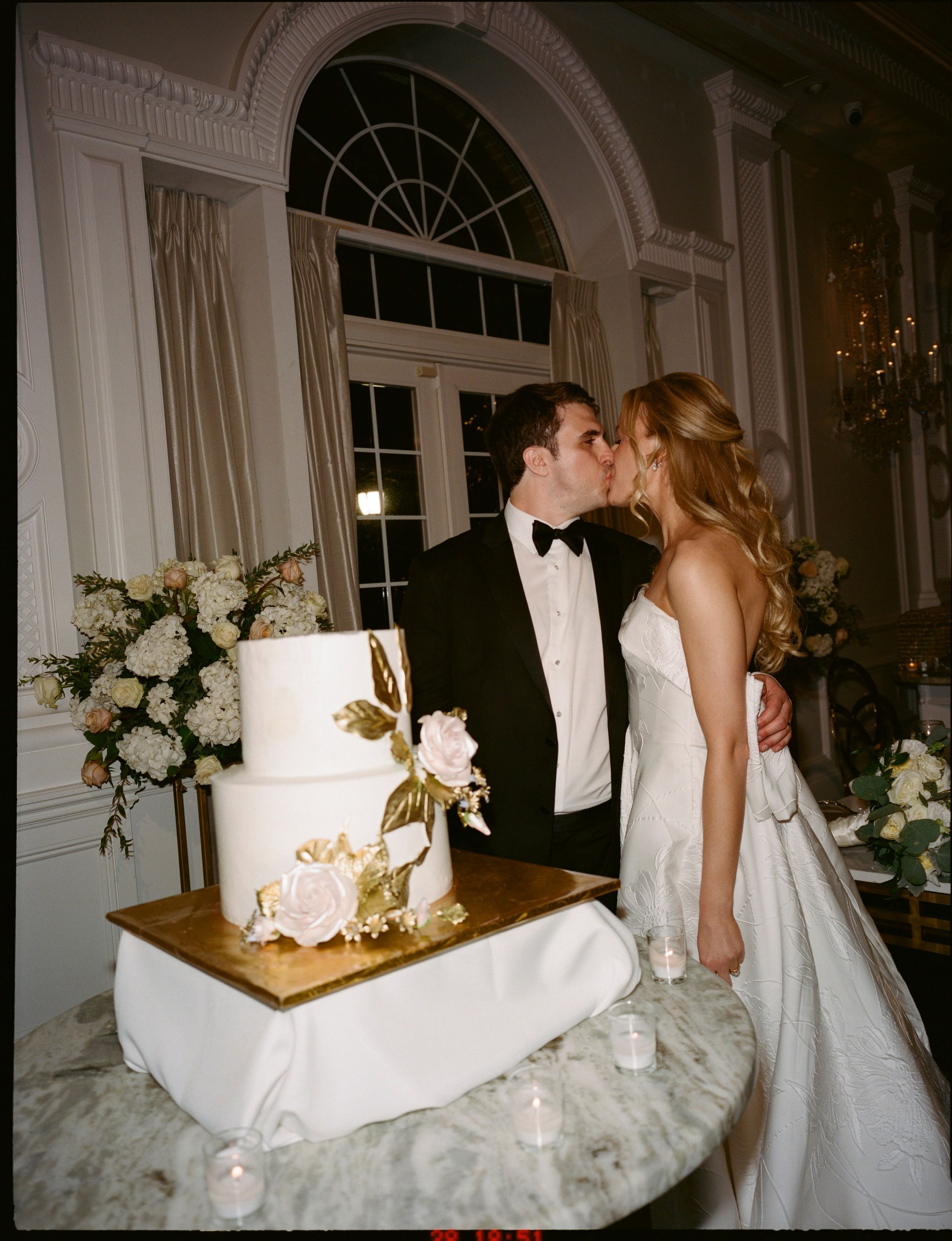 Emily and Michael sharing a moment beside their wedding cake at The Rockleigh
