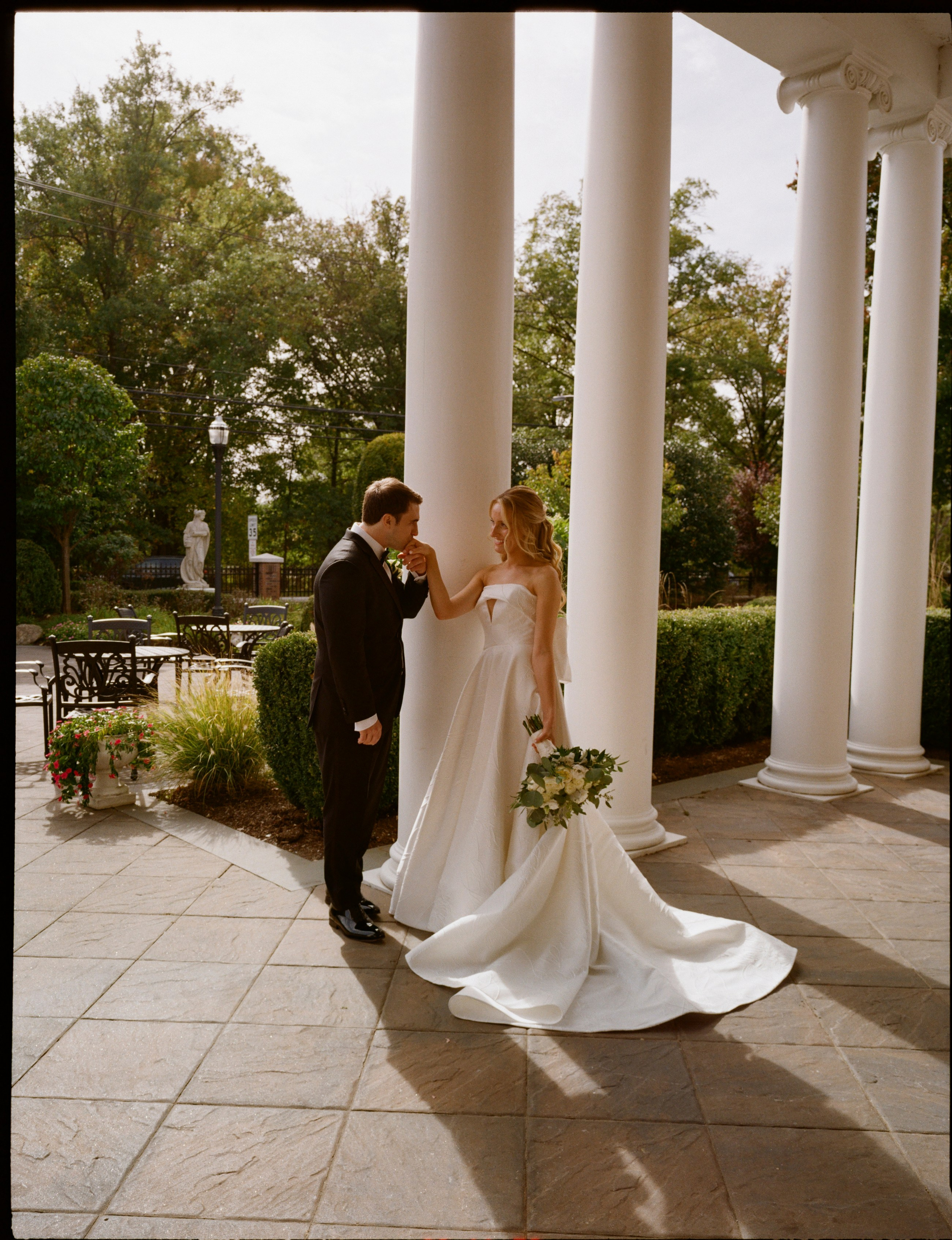 Full-length bride and groom portrait on film outside The Rockleigh in New Jersey