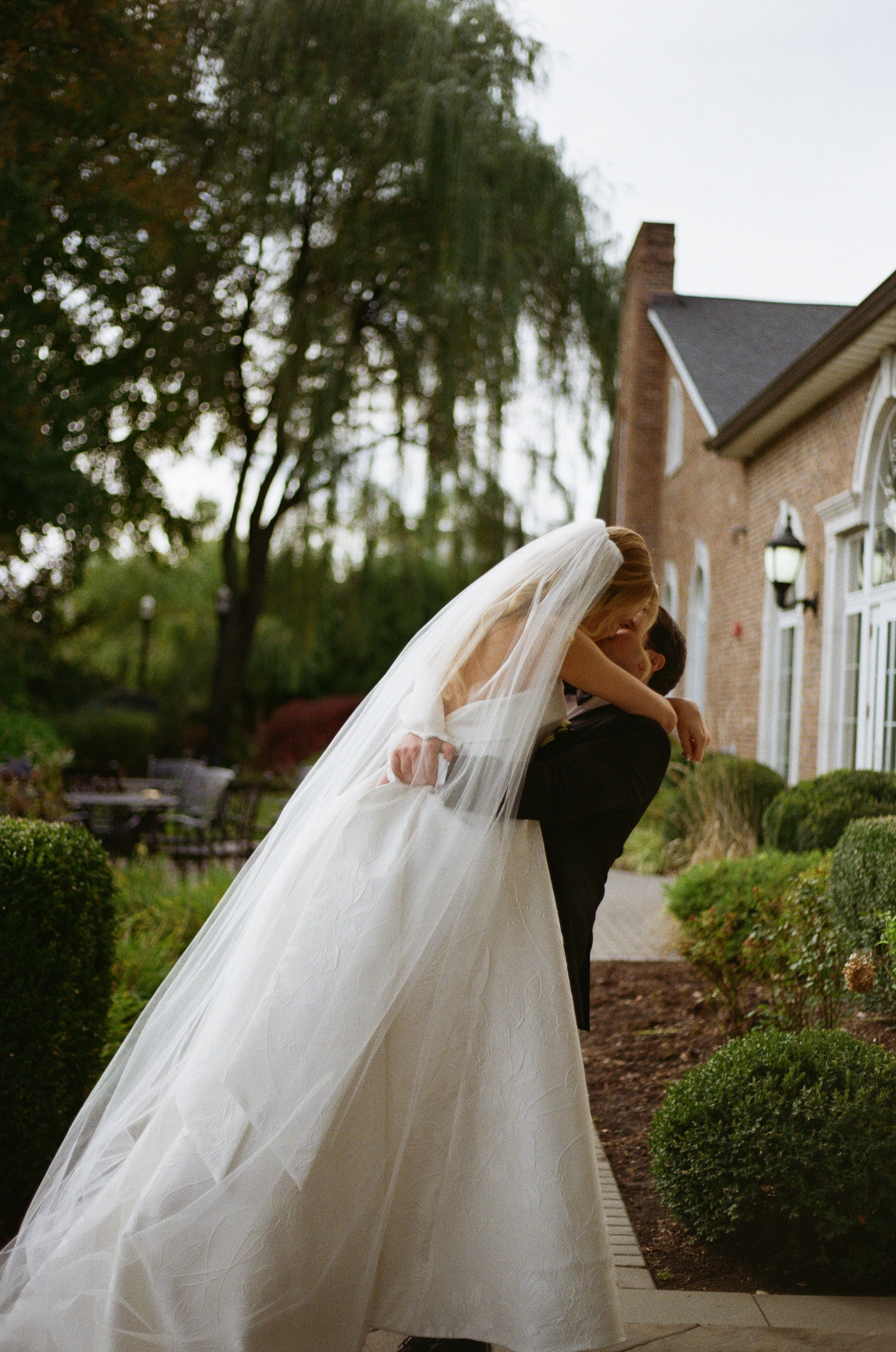 Romantic wedding portrait of Michael dipping Emily outdoors