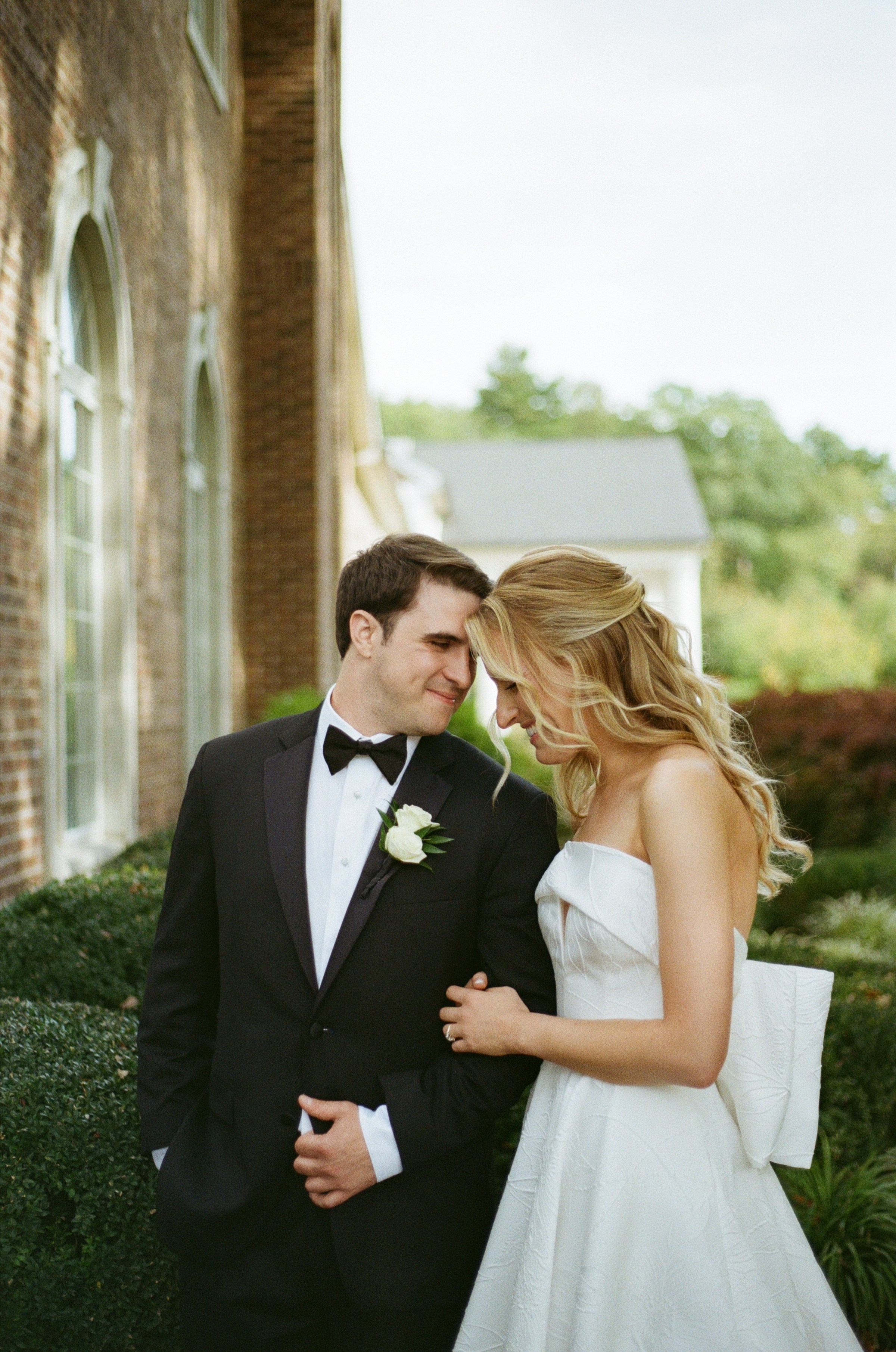 Intimate editorial portrait of Emily and Michael beside a stone column