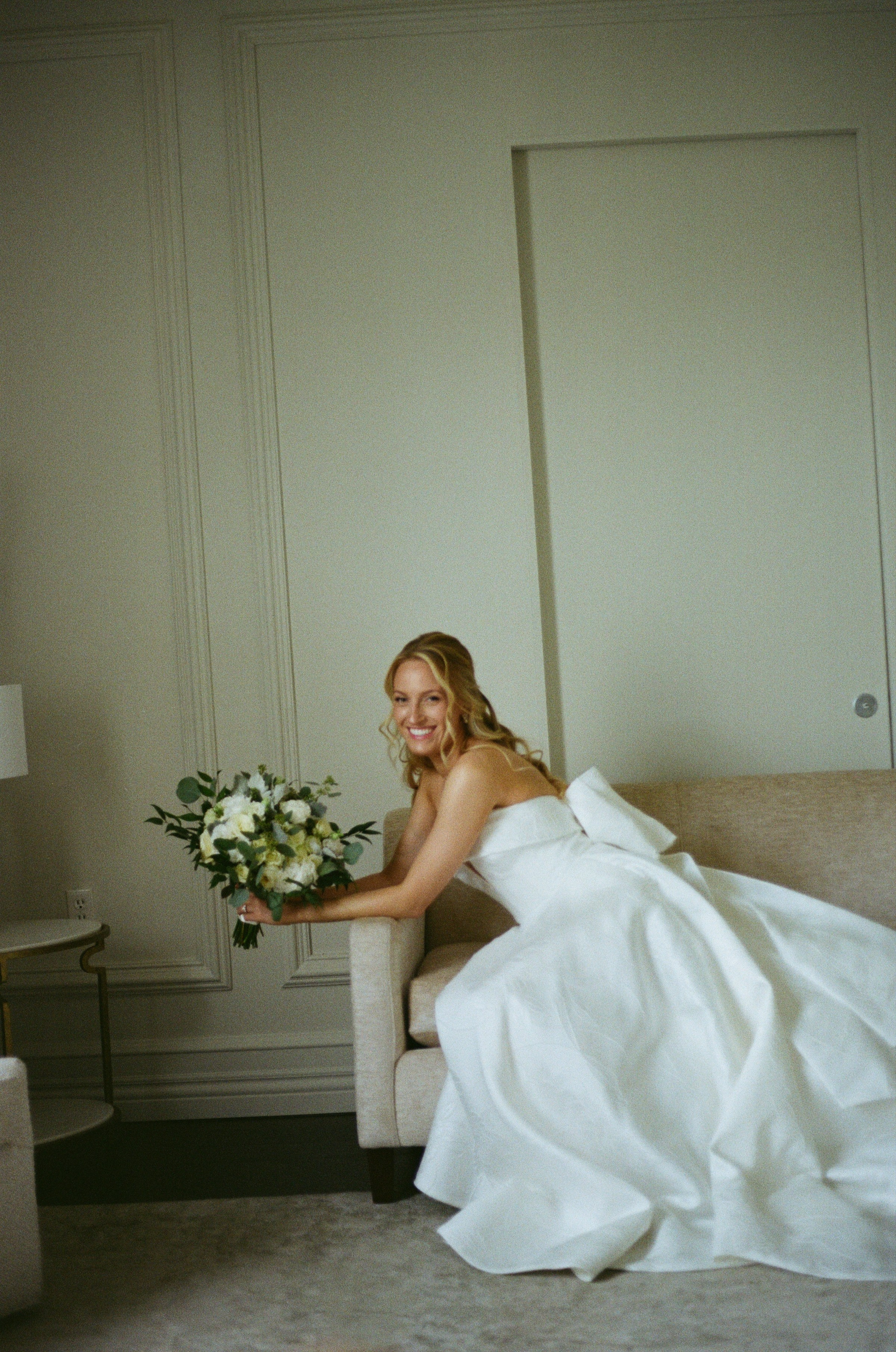 Candid bridal portrait of Emily sitting in her wedding dress