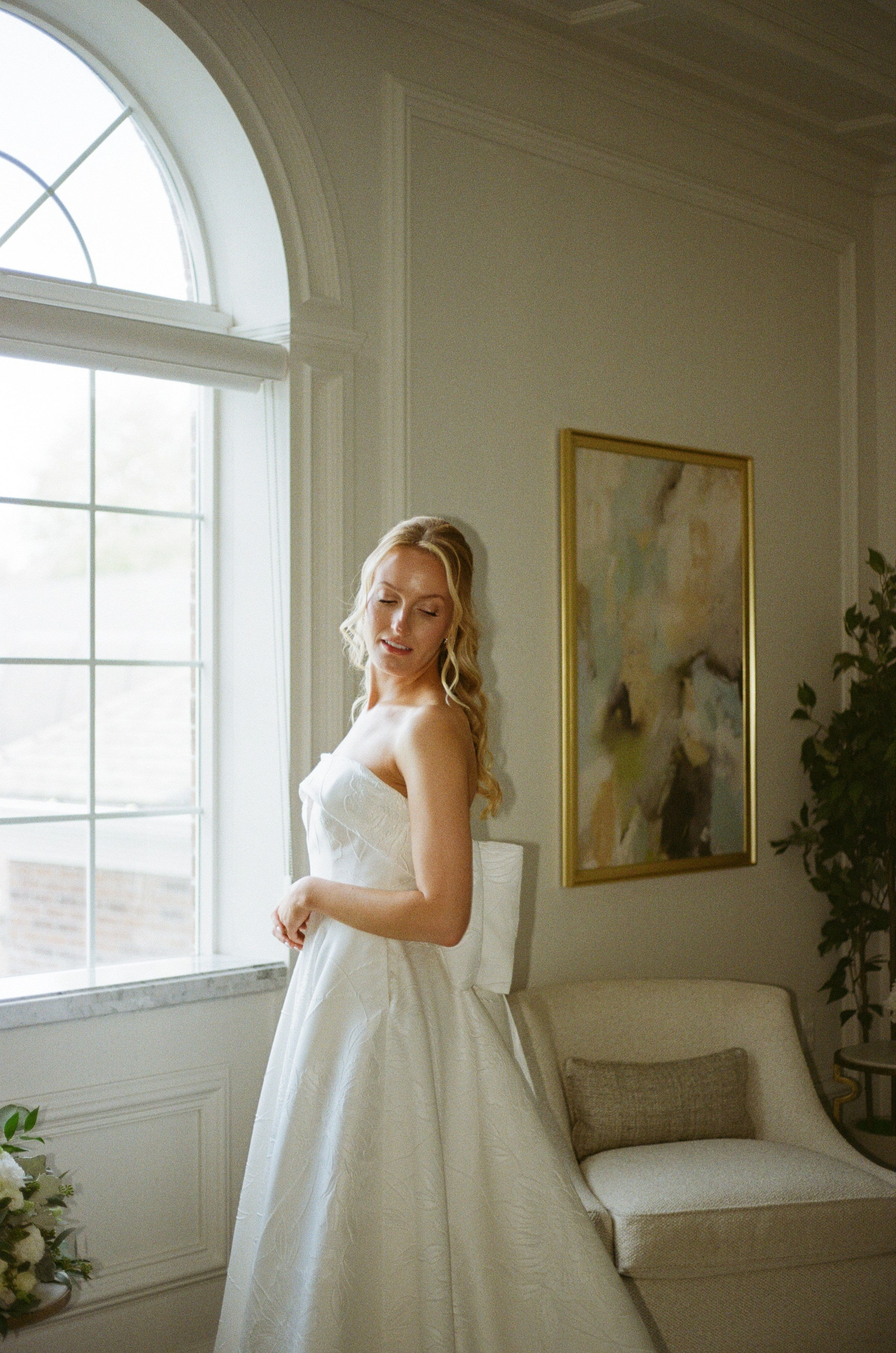 Film wedding photography of Emily beside a sunlit window