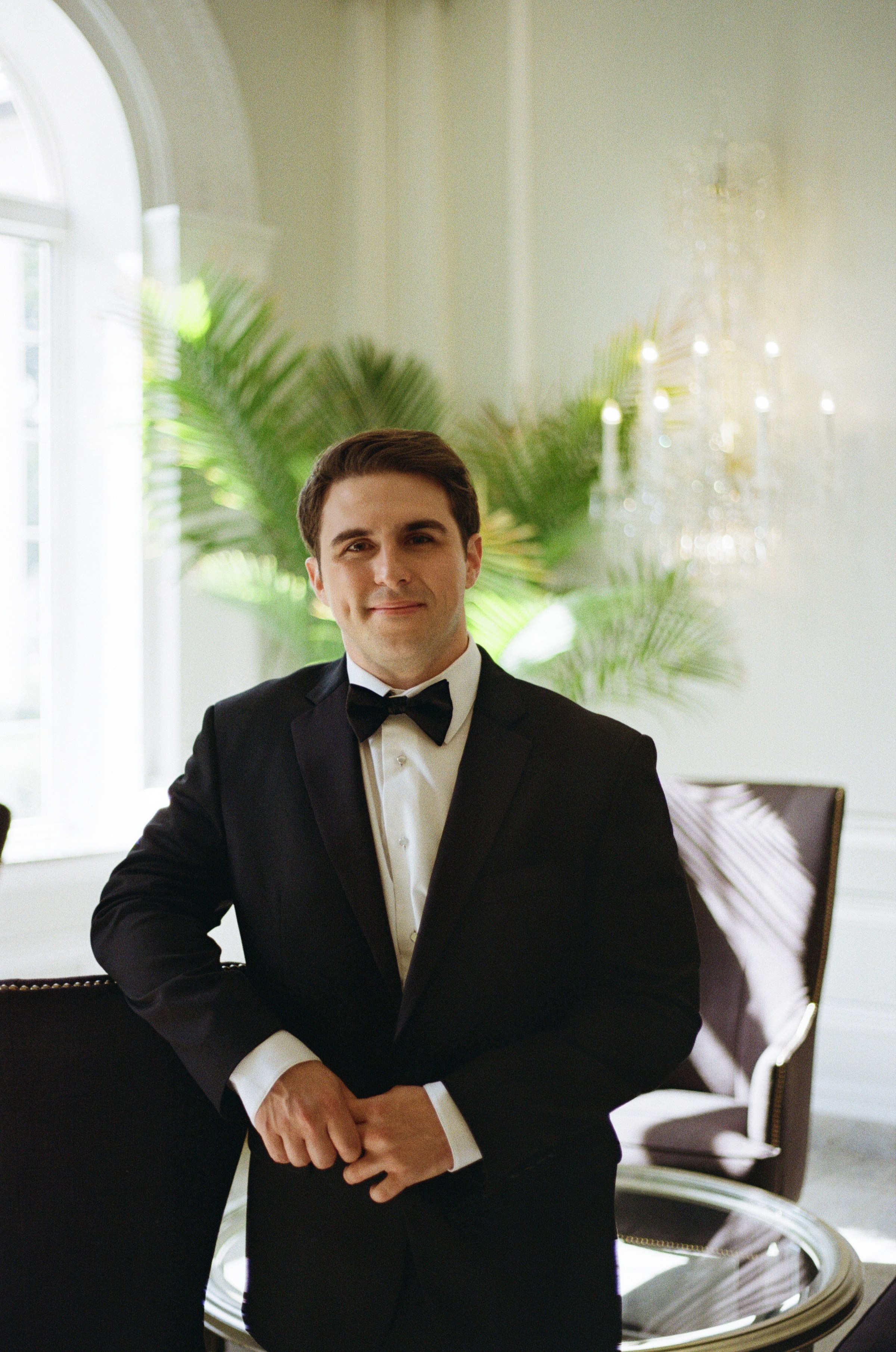 Michael getting ready in a black tuxedo on his wedding day