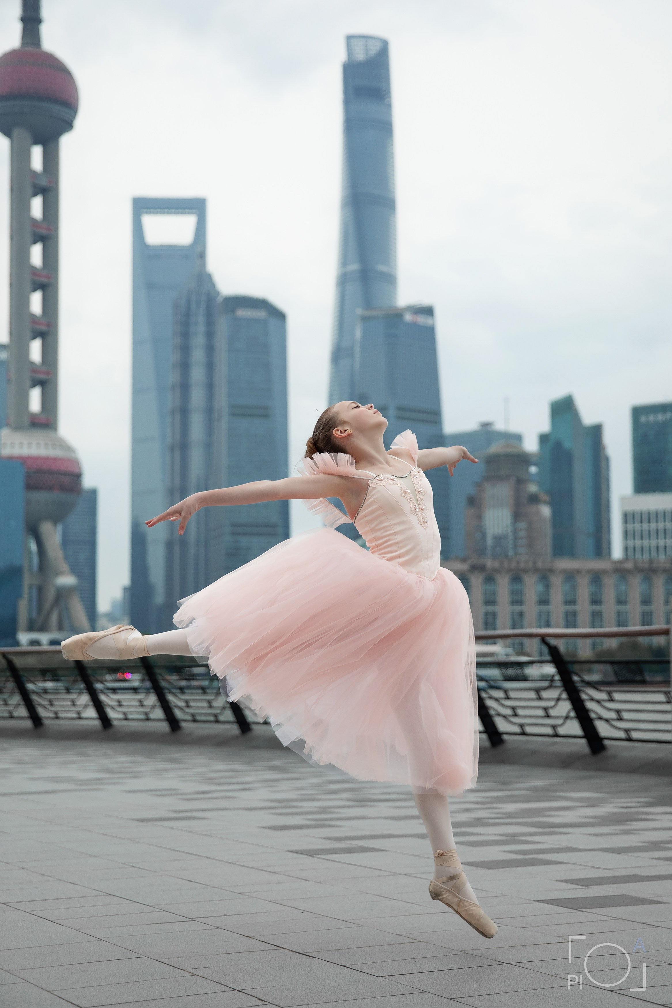 Фотосессия в Шанхае для девочки 11 лет. Маленькая балерина в розовом платье с пышной длинной пачкой, танцует на набережной в Шанхае с видом на Lujiazui