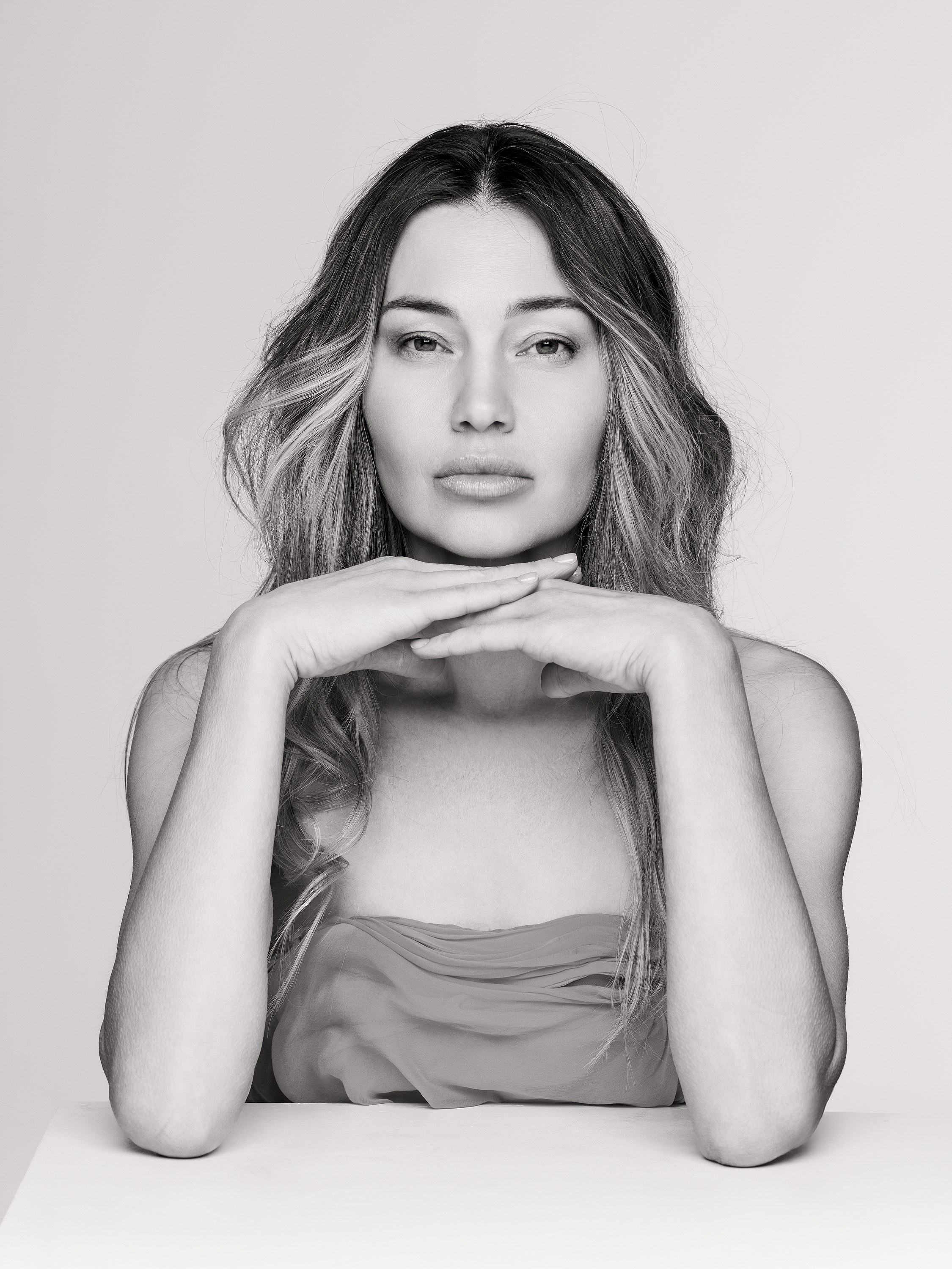 woman resting her chin on her hands, studio portrait, black and white