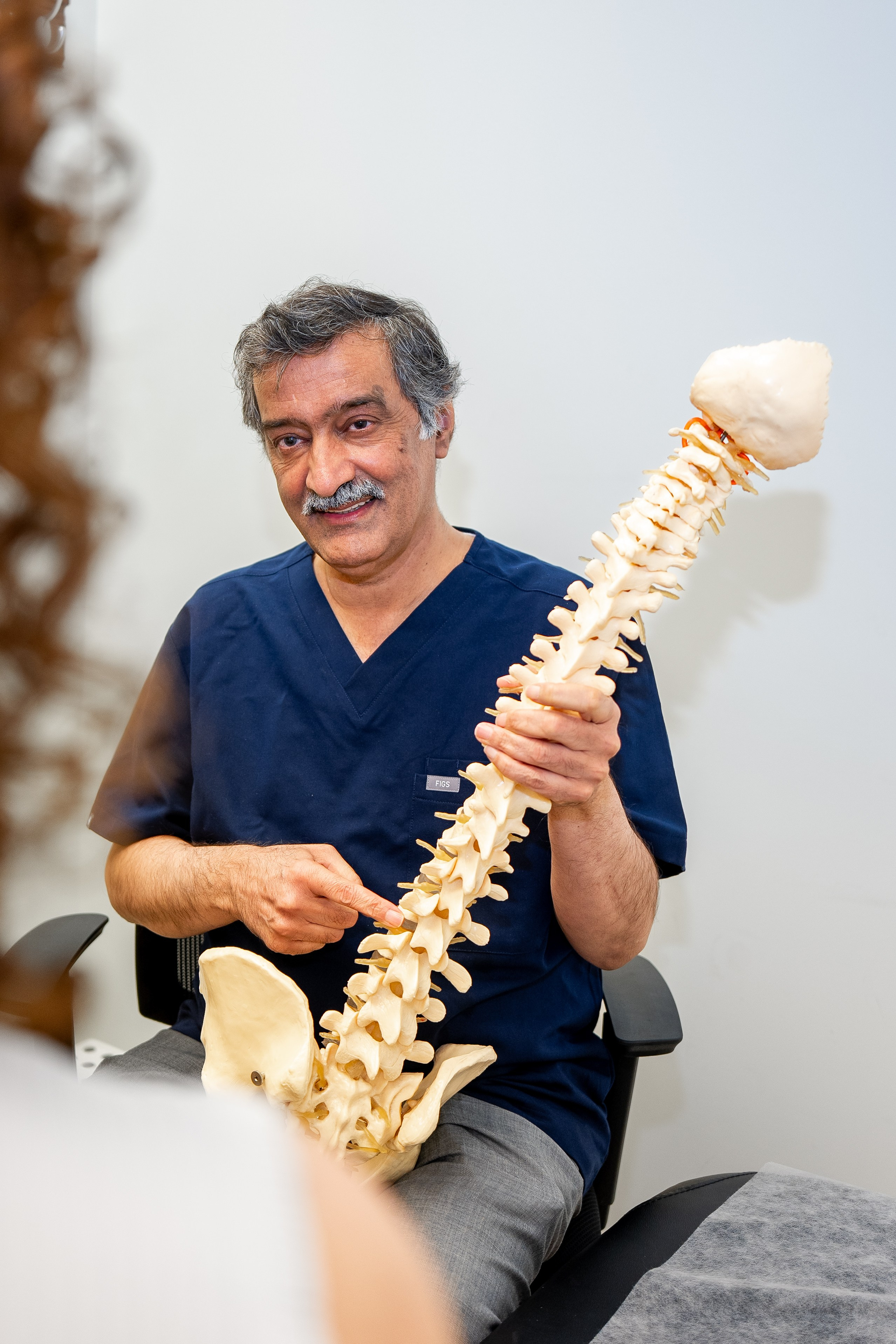 Doctor explaining spinal anatomy with model