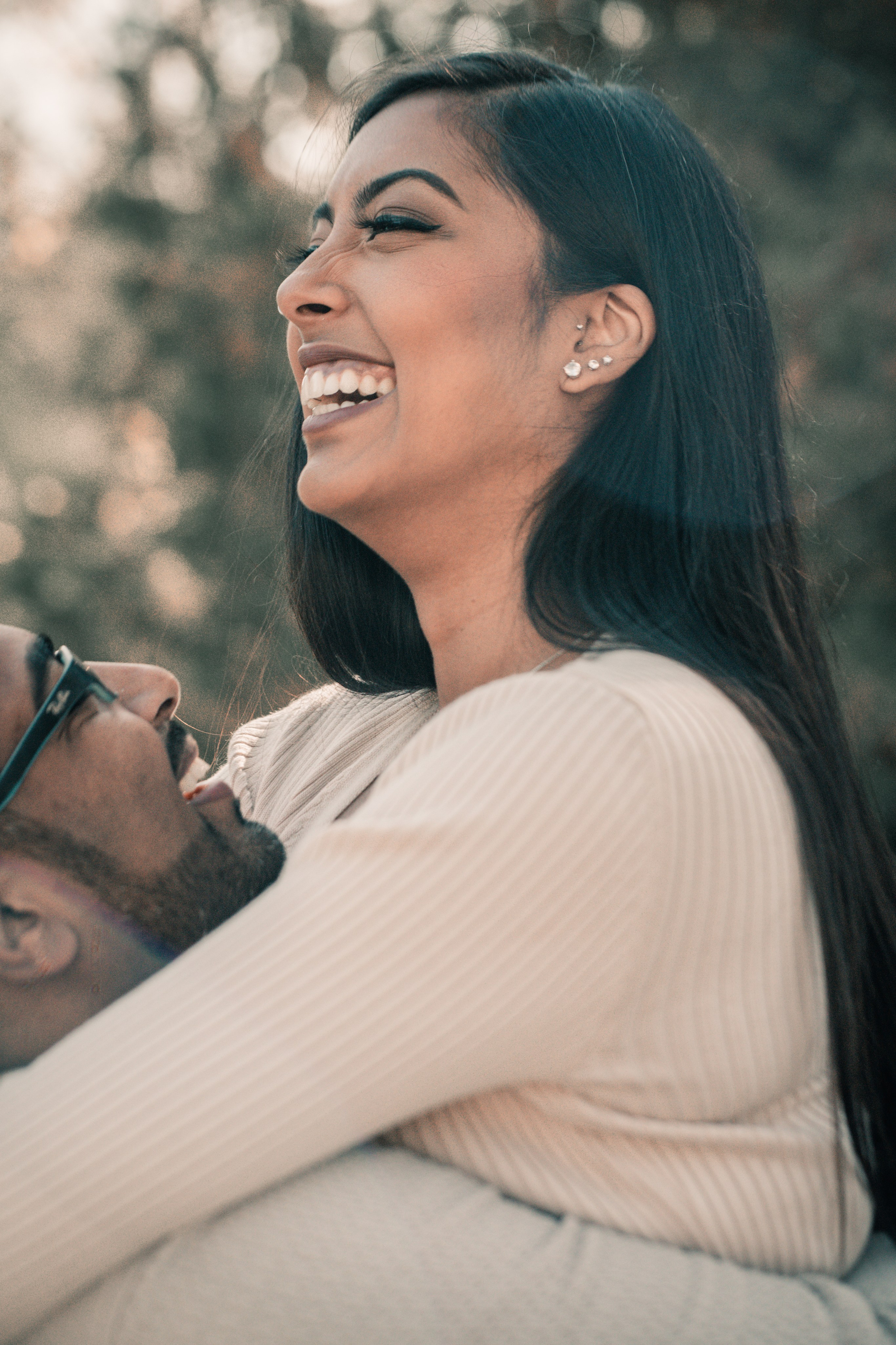 Joyful couple laughing together in downtown Toronto during their engagement session