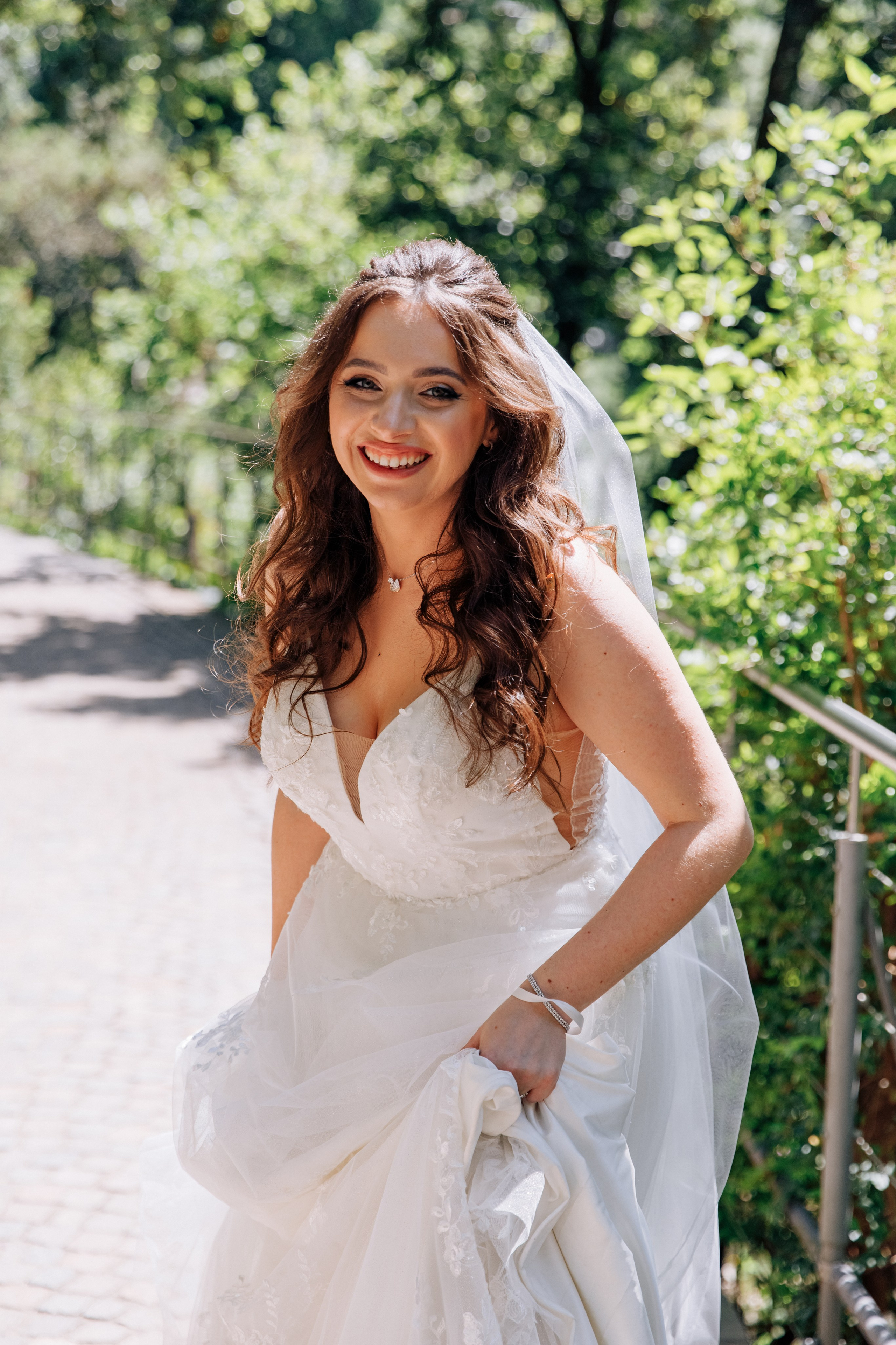 Die Braut lächelt verspielt in die Kamera, ein fröhlicher Moment der Hochzeit.