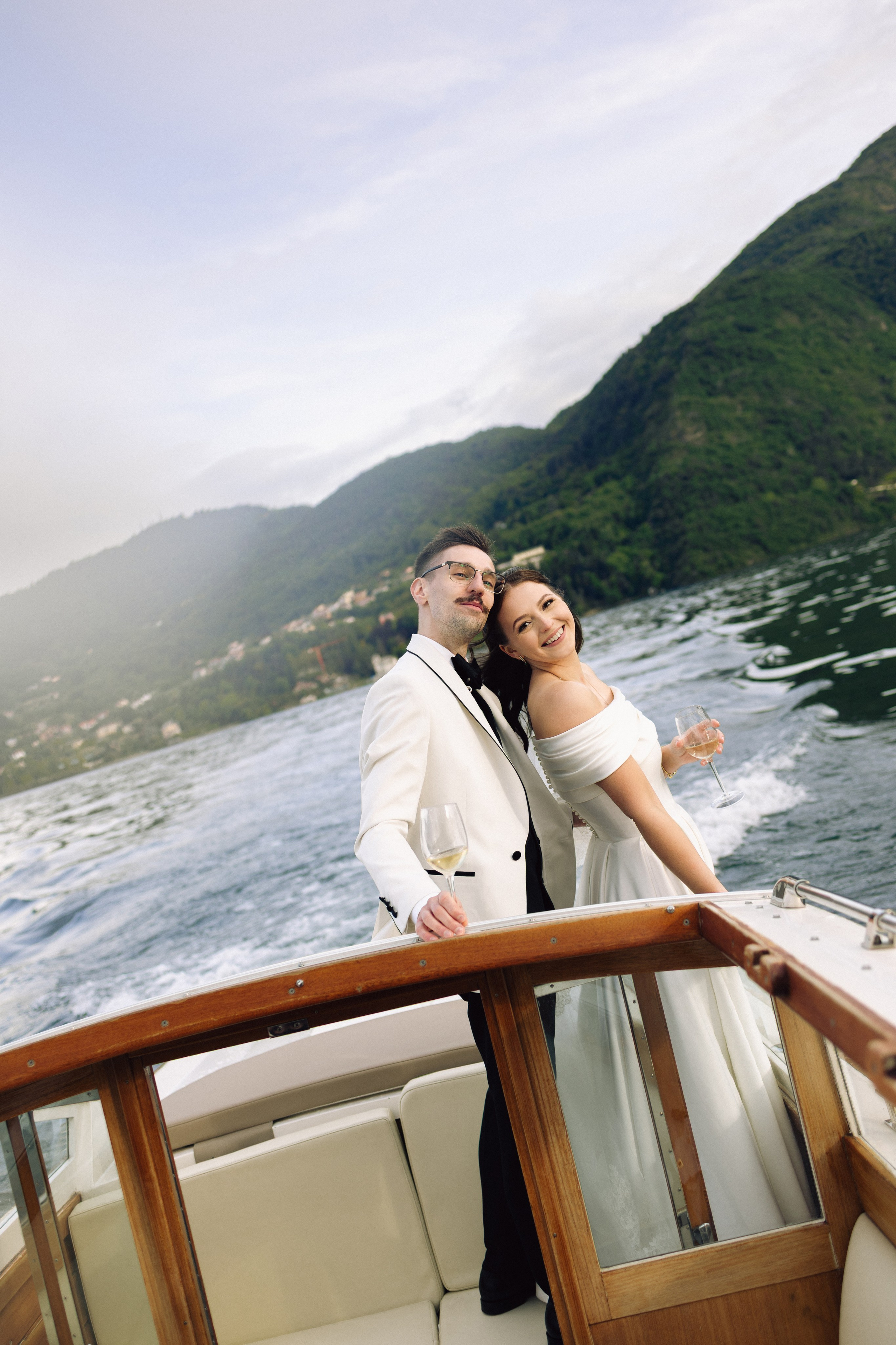 Newlyweds embracing during a romantic boat ride in Bellagio