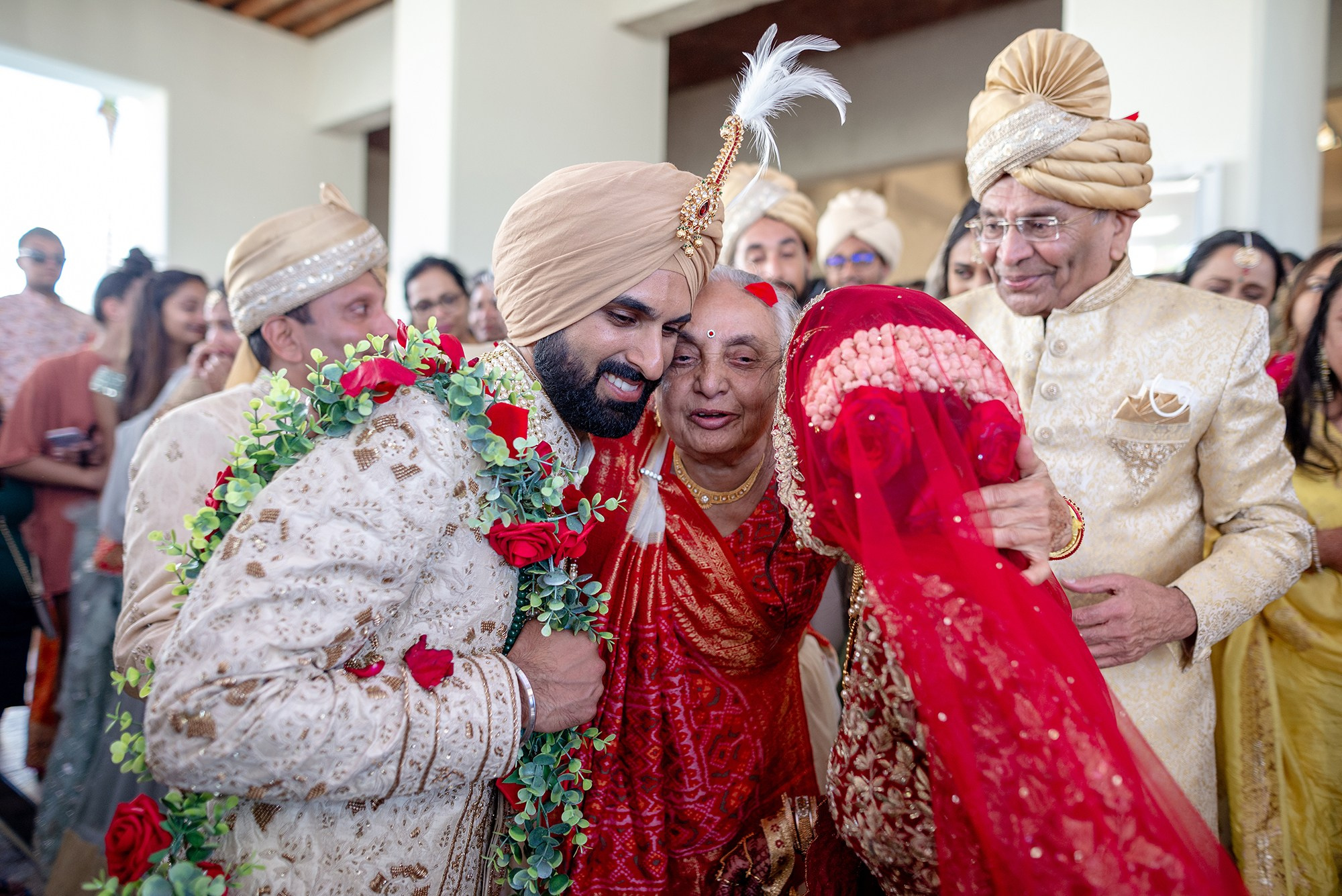 Indian wedding couple hugging grandmother during traditional ceremony at destination wedding in Los Cabos