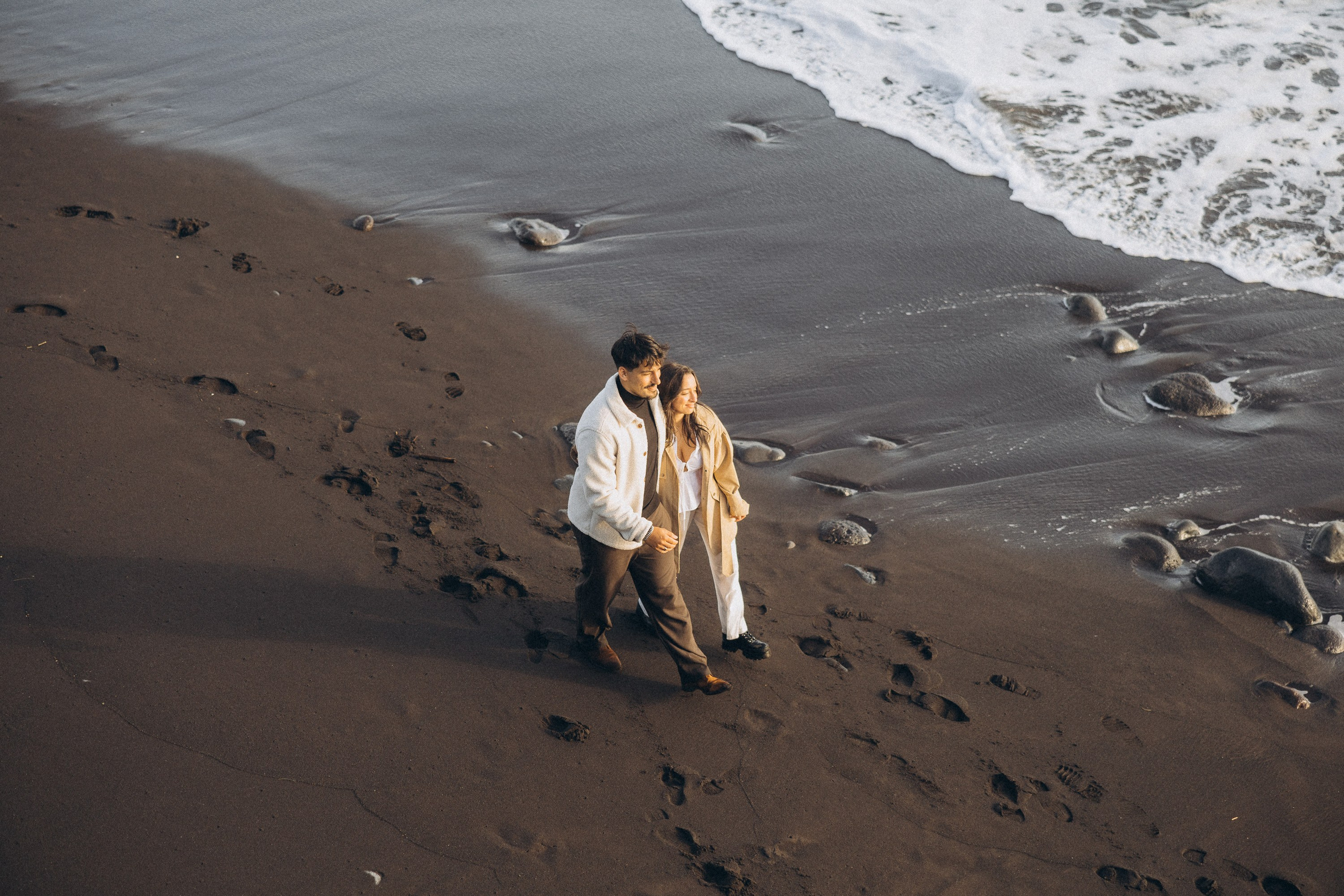 Couple sharing a romantic moment during sunset on Madeira Island, with the ocean and cliffs in the background