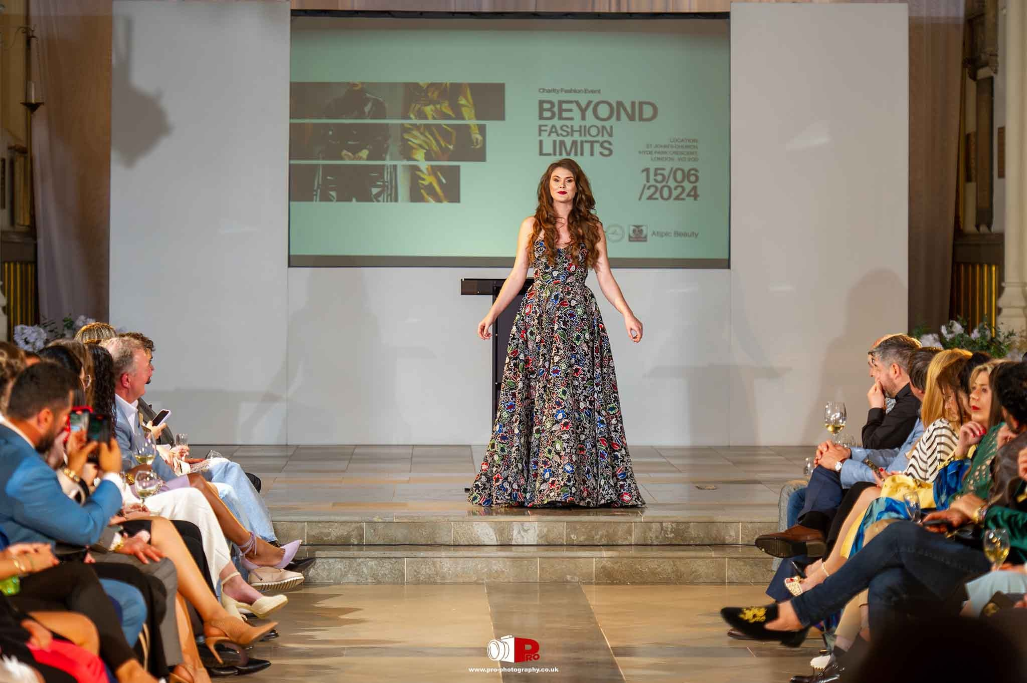 A female model in a long embroidered gown walks the runway at the Beyond Fashion Limits event.