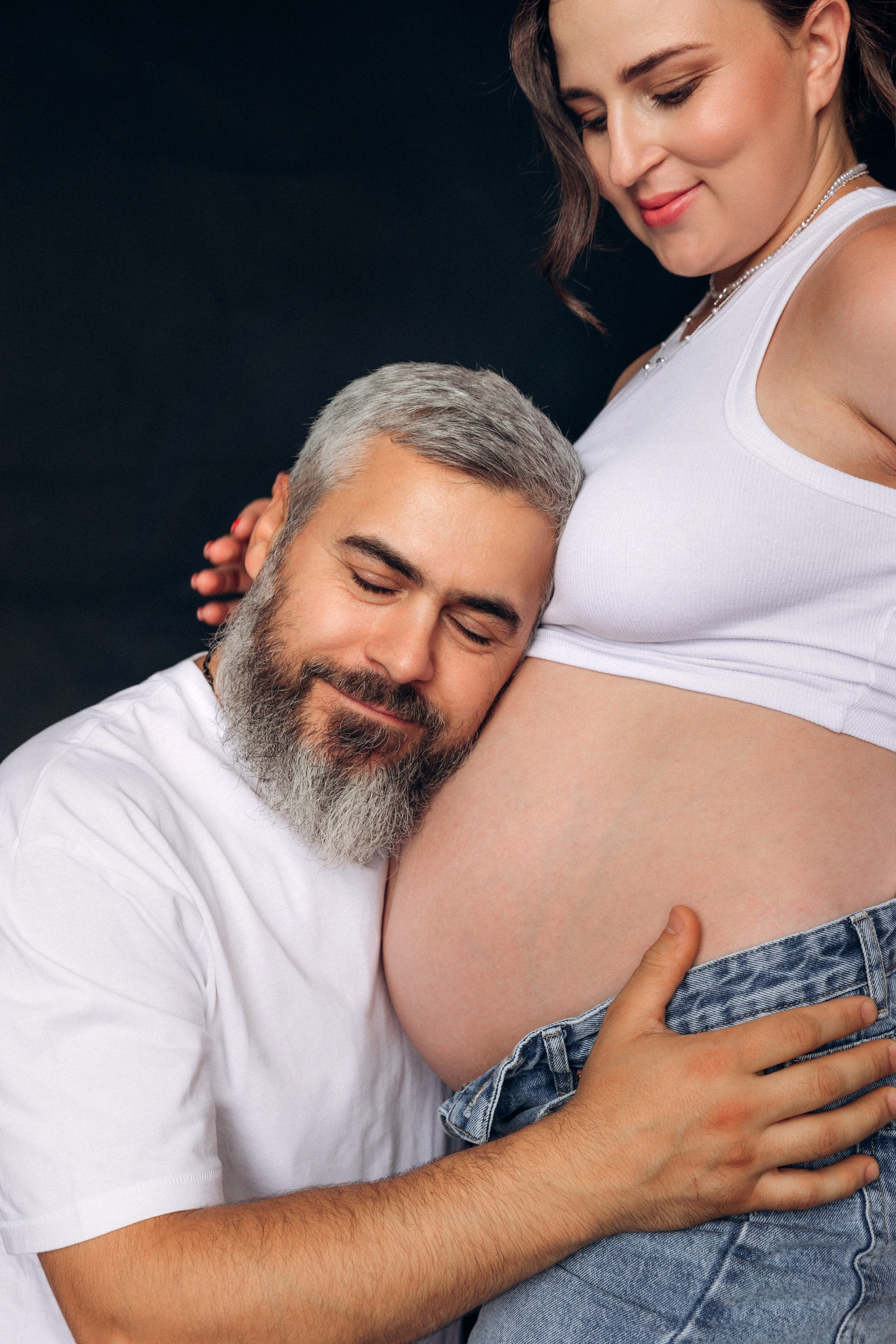 Swobodna i radosna sesja ciążowa – para śmieje się, uchwycony autentyczny moment bliskości.