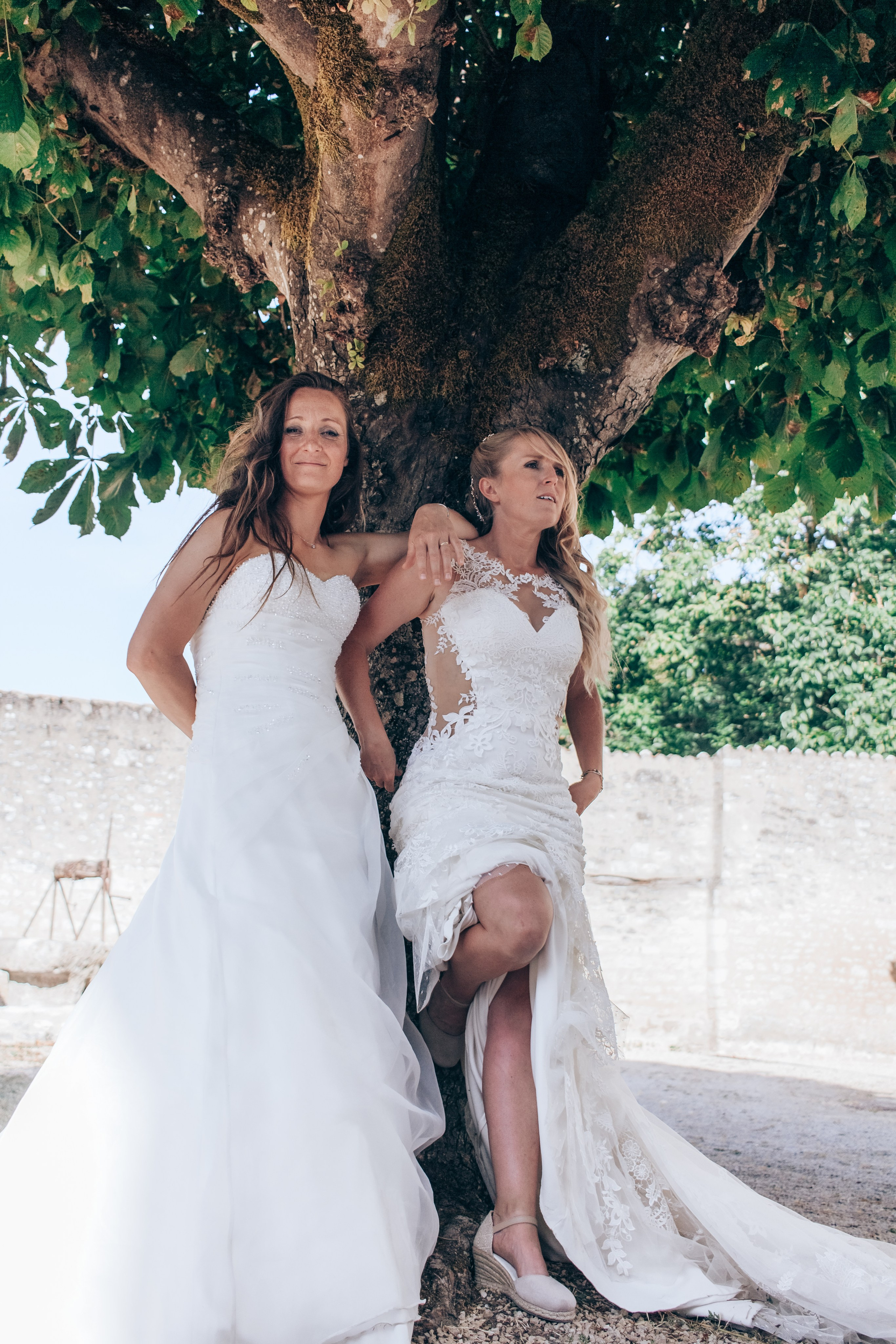 Couple de femmes en robes de mariées marchant ensemble, séance photo romantique