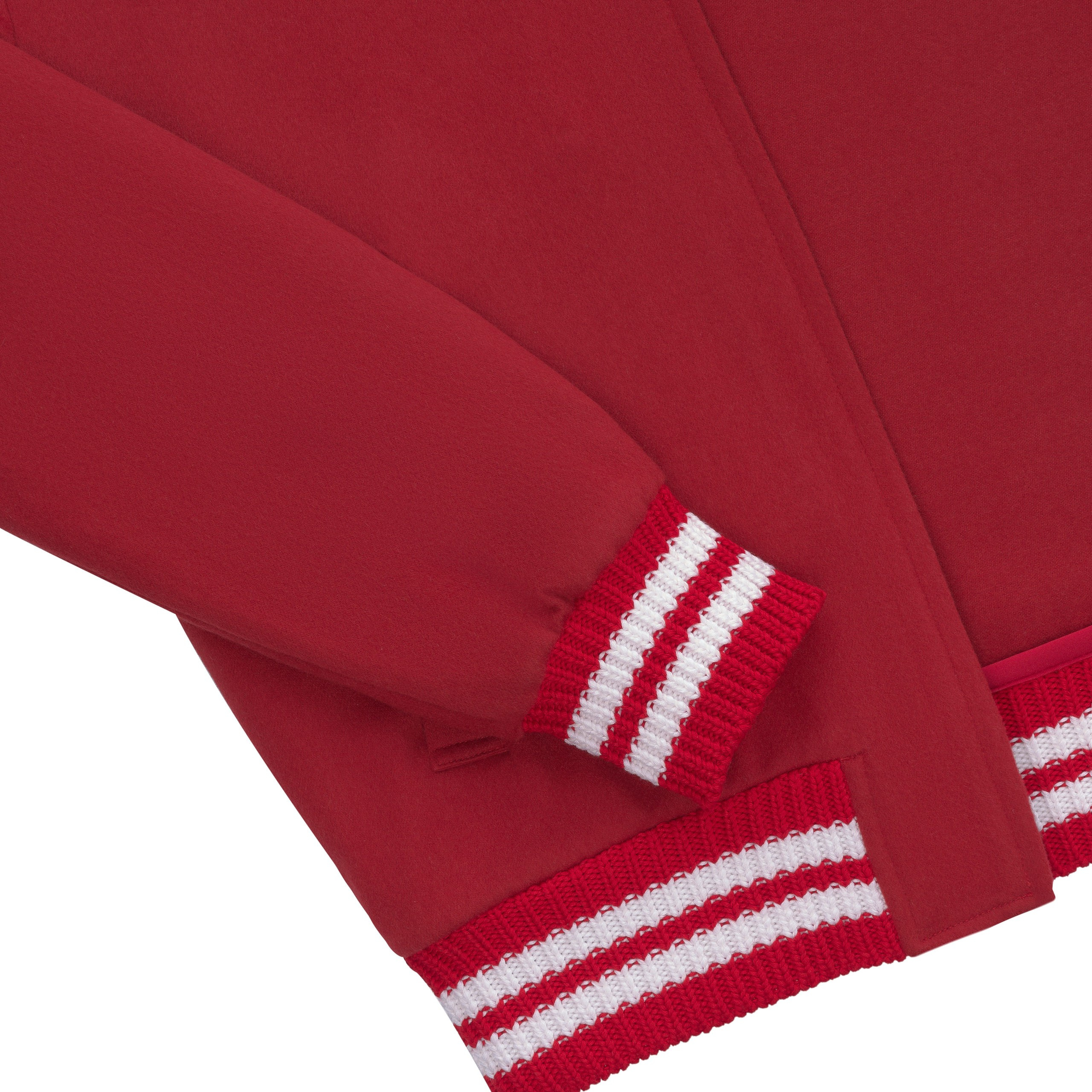 Detailaufnahme – Ärmelabschluss mit gestreiftem Bündchen der roten Jacke.