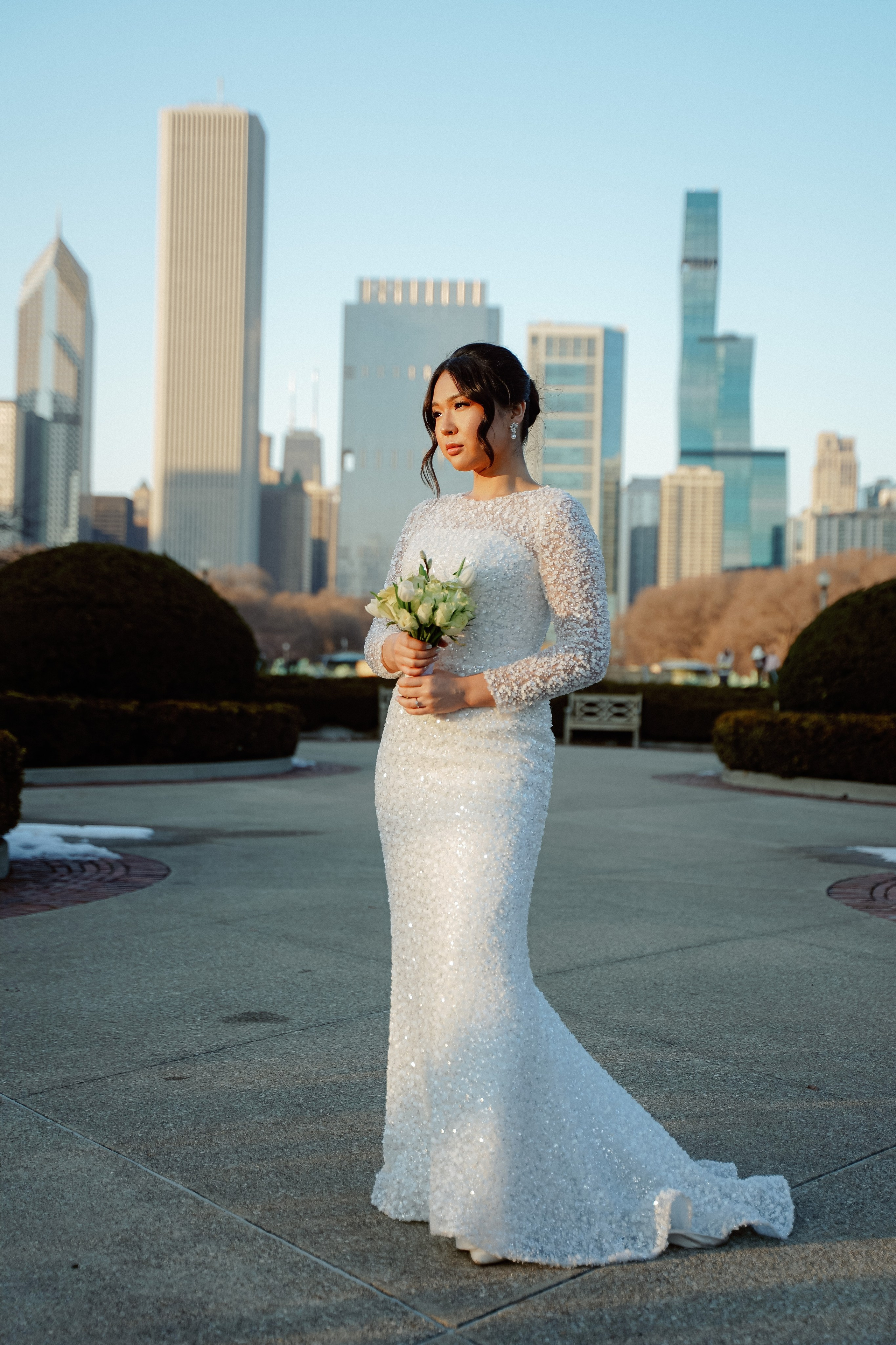 Bride and groom wedding portrait at Millennium Park Chicago with downtown skyline view and romantic city atmosphere.