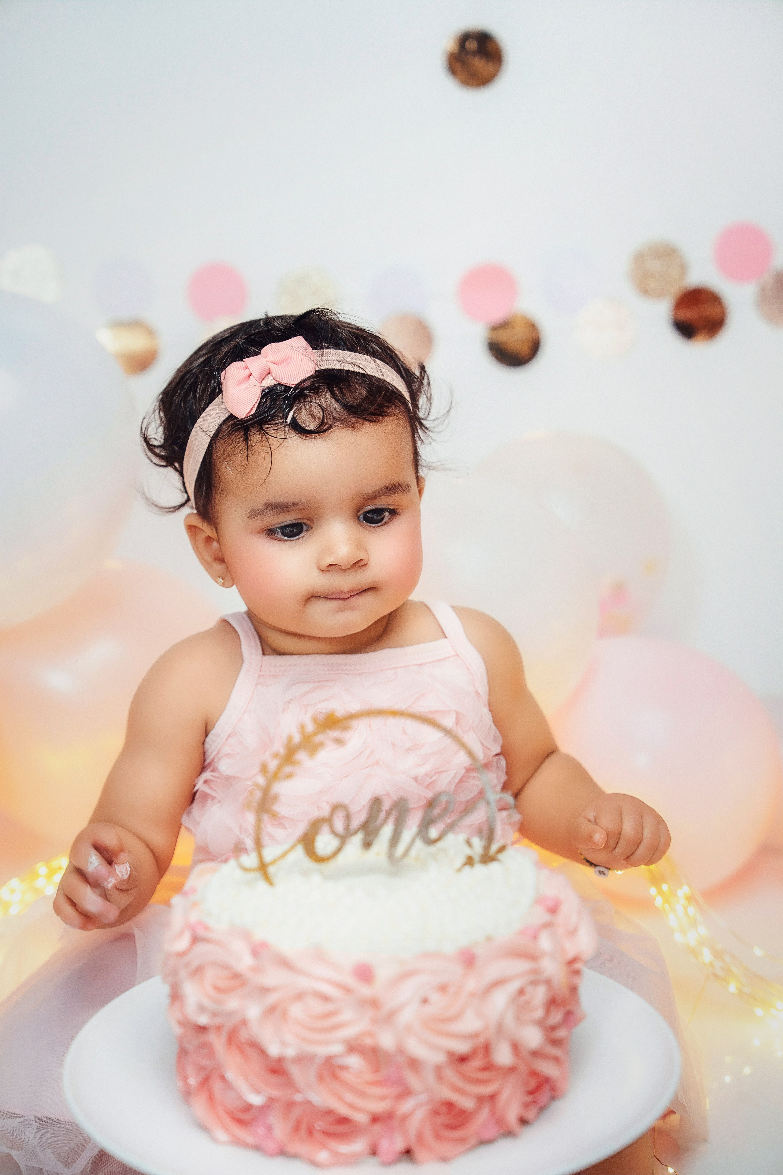 Cake Smash в мягких тонах: улыбающийся малыш празднует свой первый год.