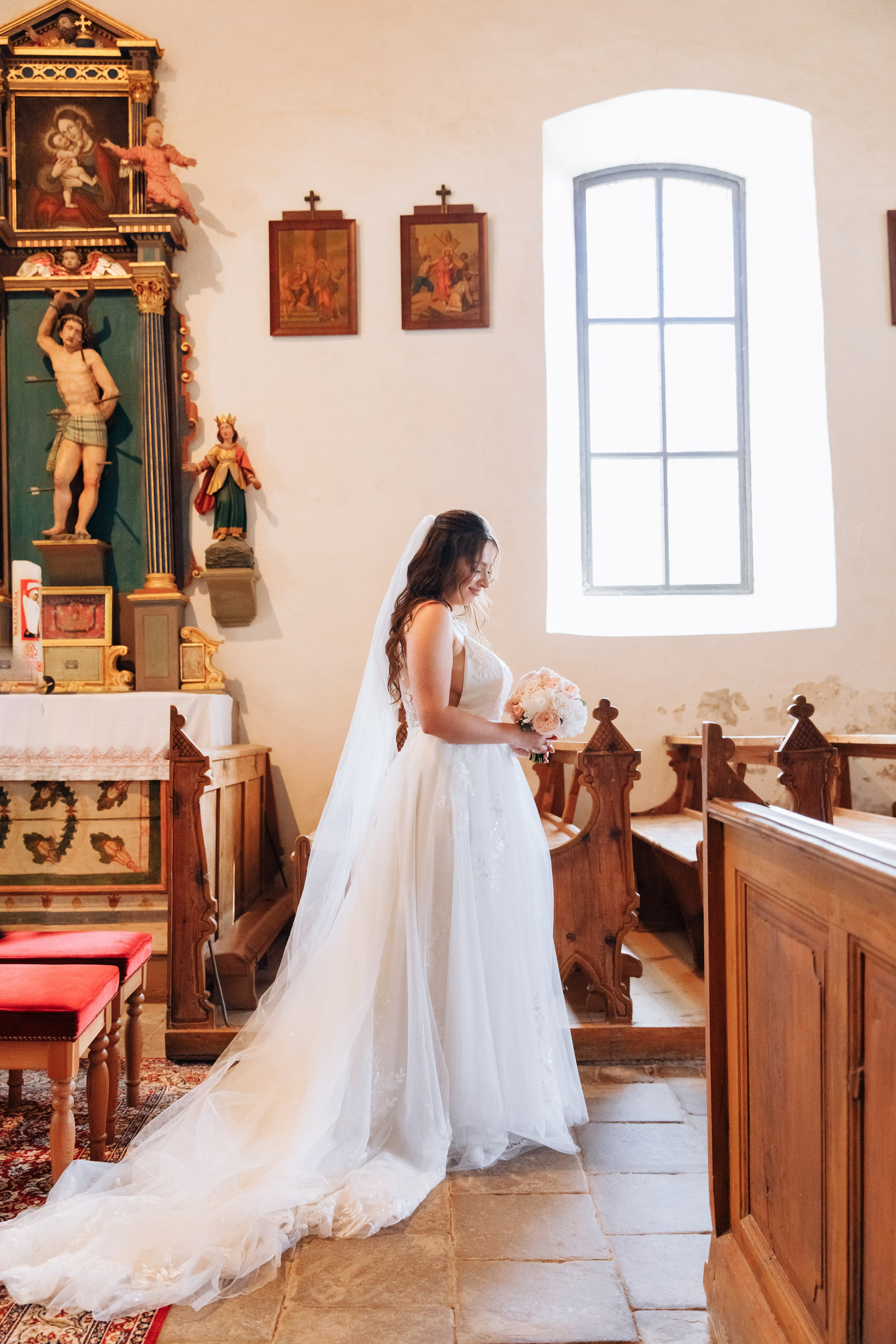 Die Braut steht mitten in der Kirche, umgeben von hellem Licht.